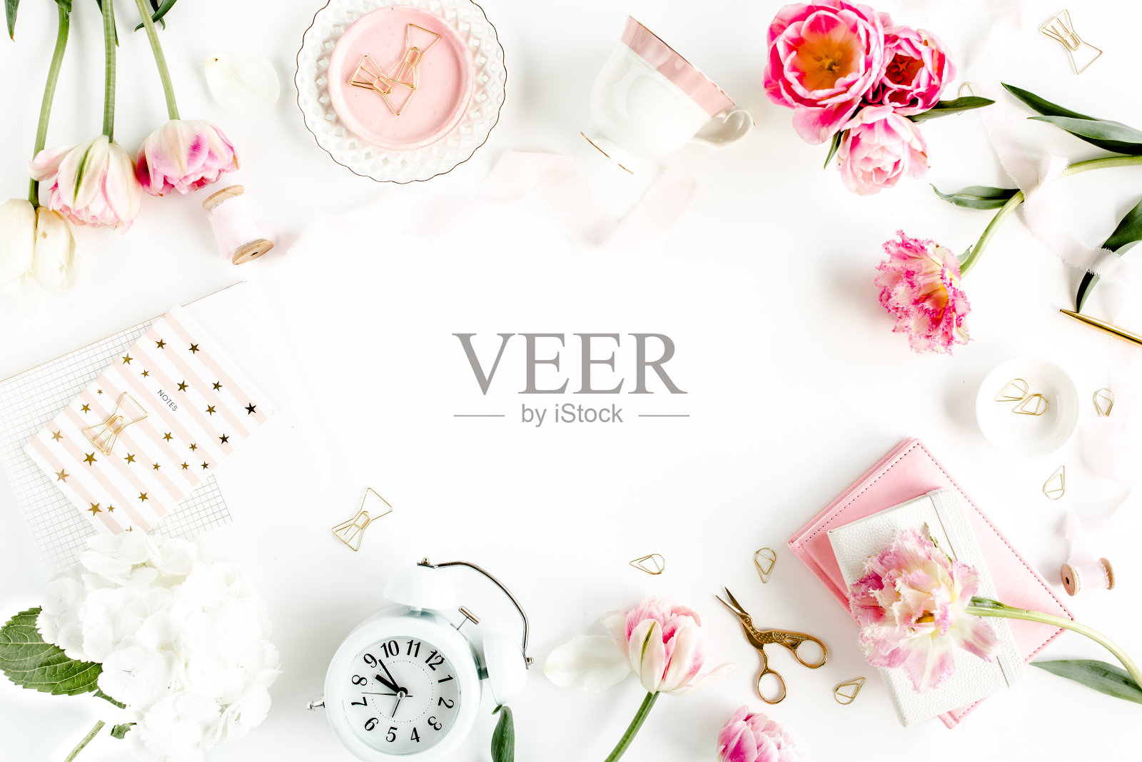 时尚博客粉红色风格的书桌,配有饰品,郁金香花,剪刀,白色背景上的咖啡杯。平的。俯视图照片摄影图片