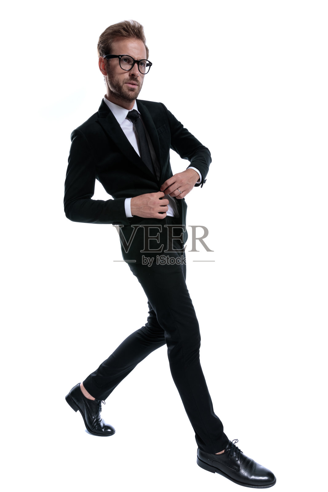 戏剧性的酷商人调整西装和自信的行走照片摄影图片