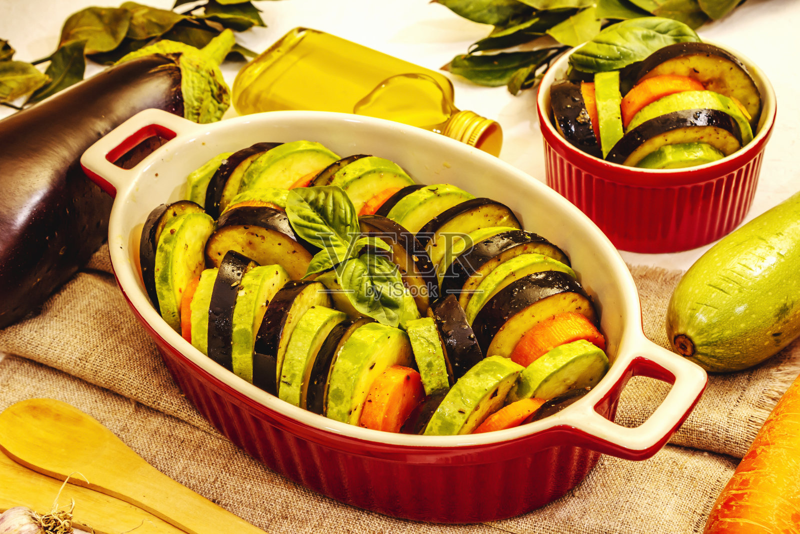 烤用新鲜蔬菜。橄榄油,茄子,西葫芦,胡萝卜,香料和罗勒照片摄影图片