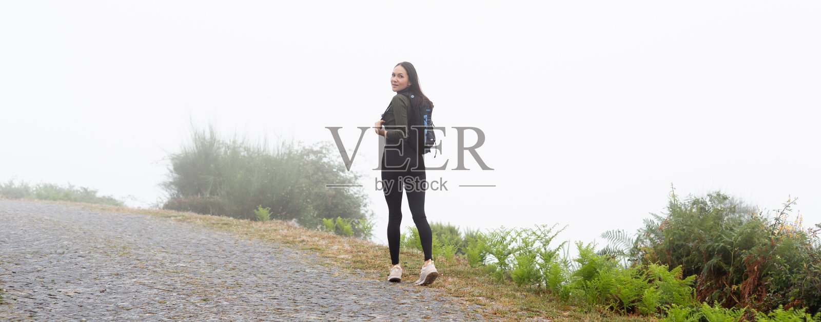 背着背包的年轻女子徒步旅行者在户外的山区旅行照片摄影图片