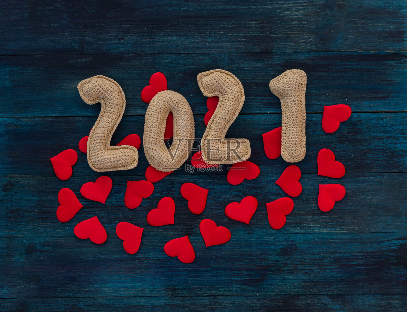浪漫的圣诞背景编织数字21和红色的心在蓝色的木制背景照片摄影图片