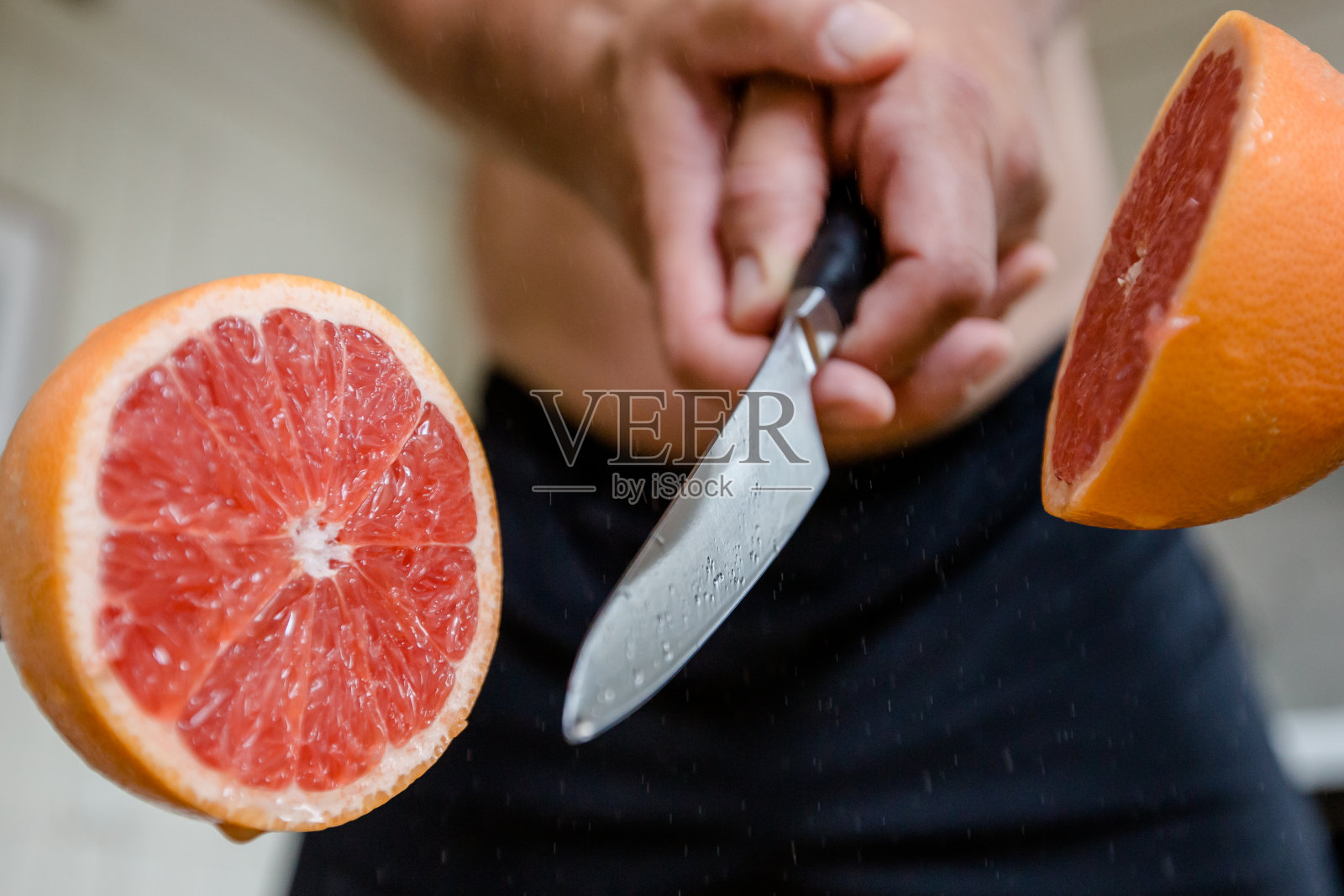 葡萄柚是用一把锋利的刀在空中切的照片摄影图片