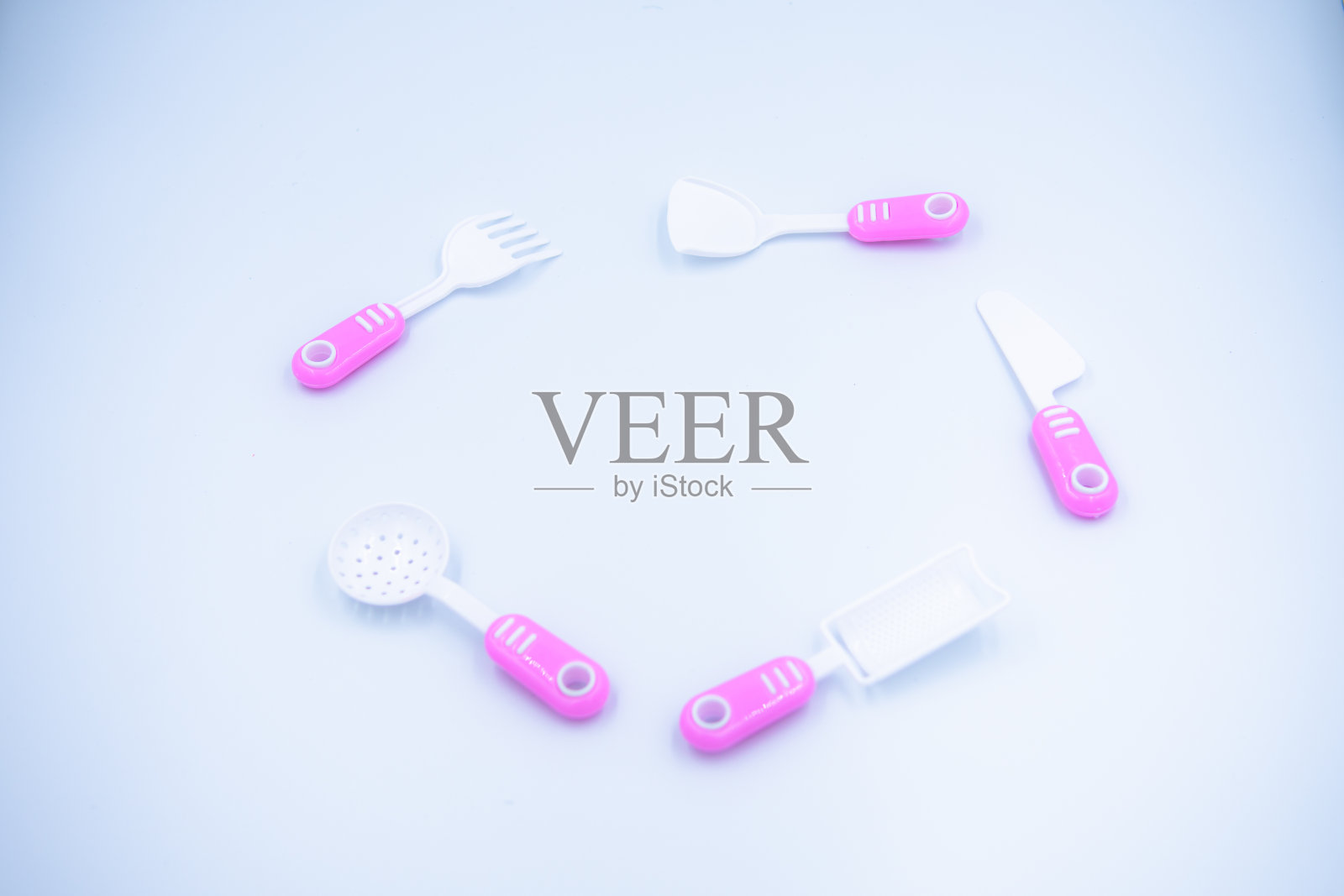 儿童的粉色塑料炊具,用于在白色背景上烹饪照片摄影图片