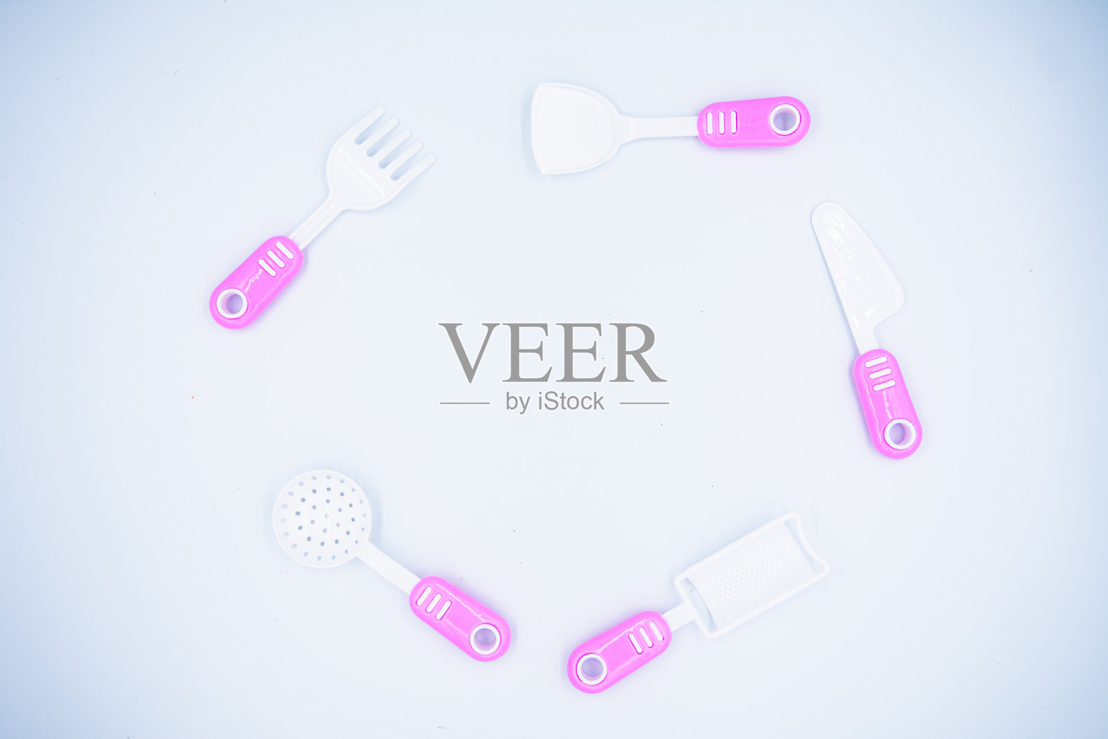 儿童的粉色塑料炊具,用于在白色背景上烹饪照片摄影图片