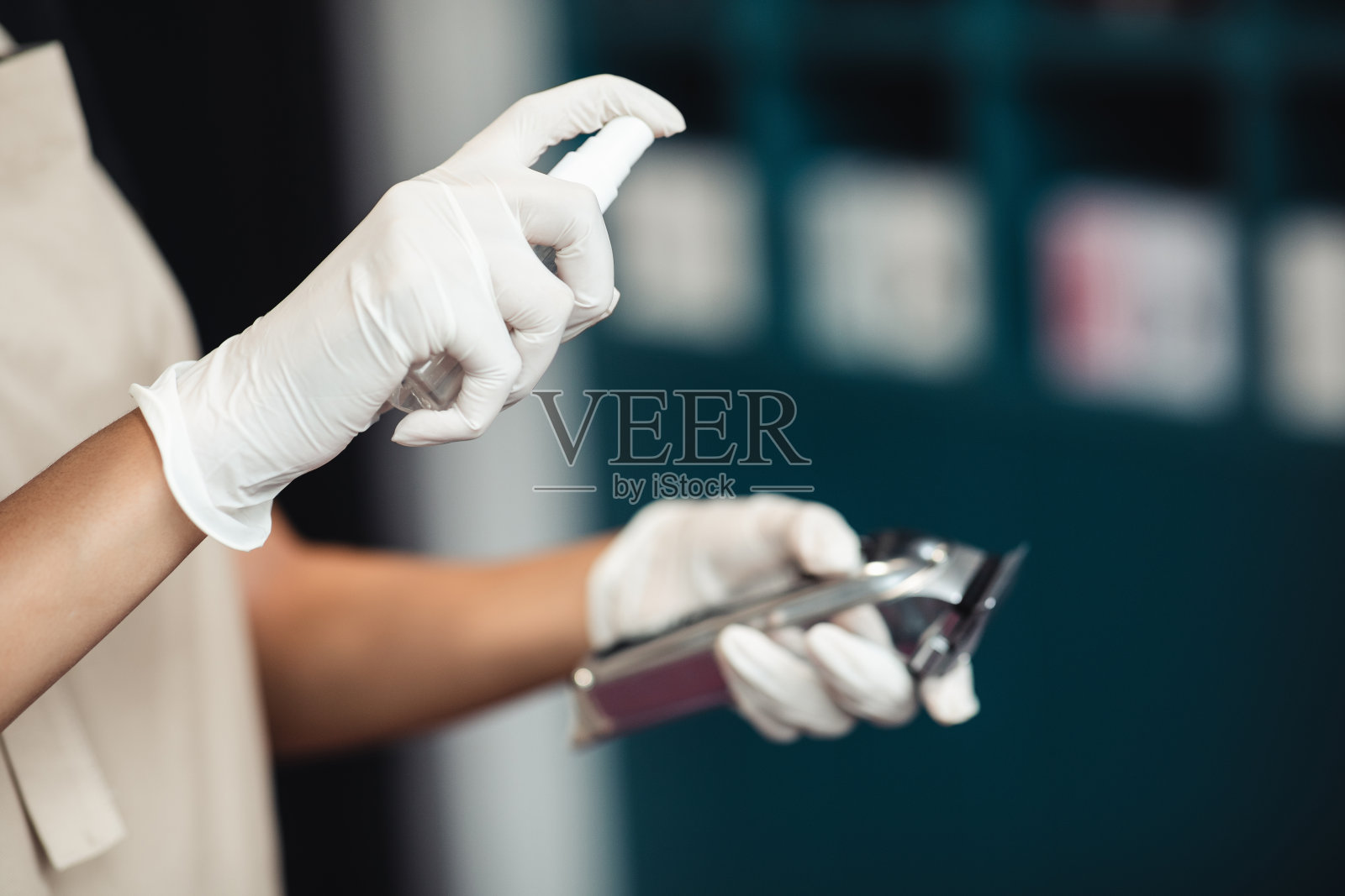 在电动修剪机上喷洒消毒剂的师傅手的特写照片摄影图片