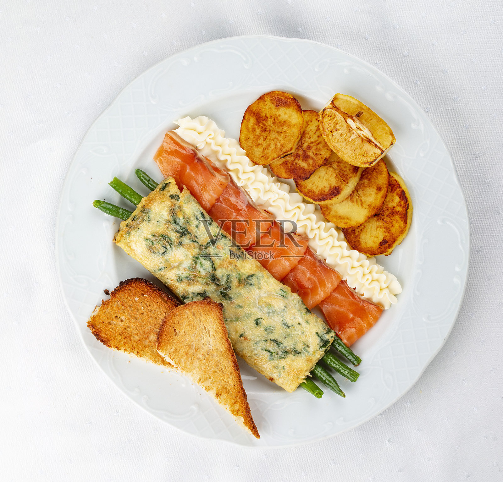 早餐。煎蛋卷配鲑鱼、芦笋、烤土豆和油炸面包丁照片摄影图片