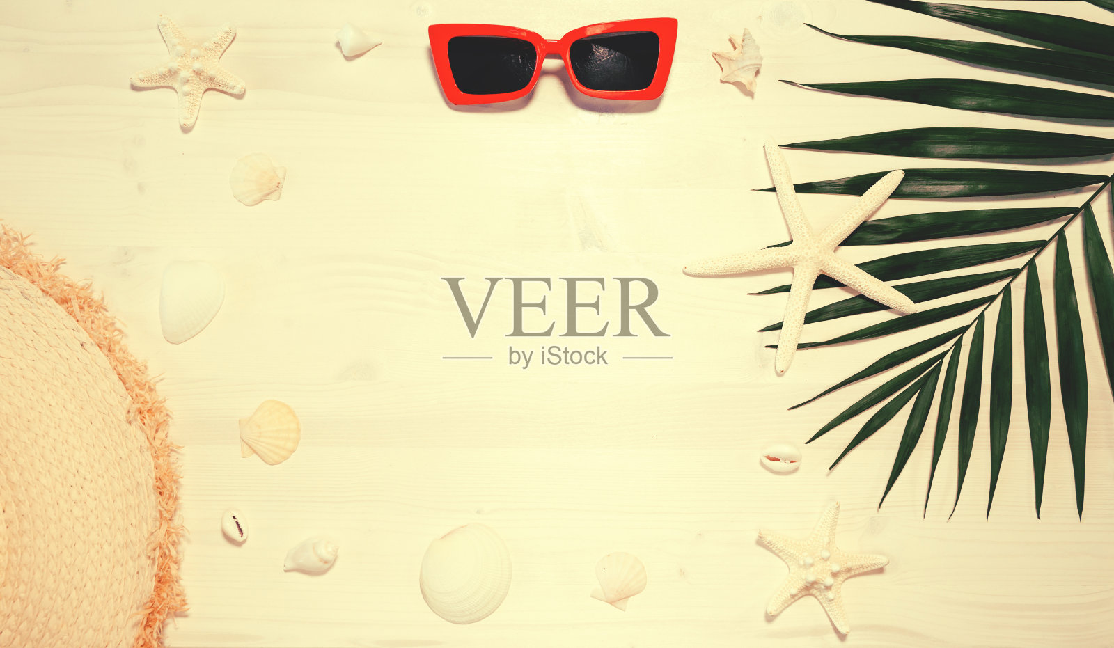 夏日写真,木桌上有太阳镜、草帽、海星、贝壳和棕榈叶。照片摄影图片