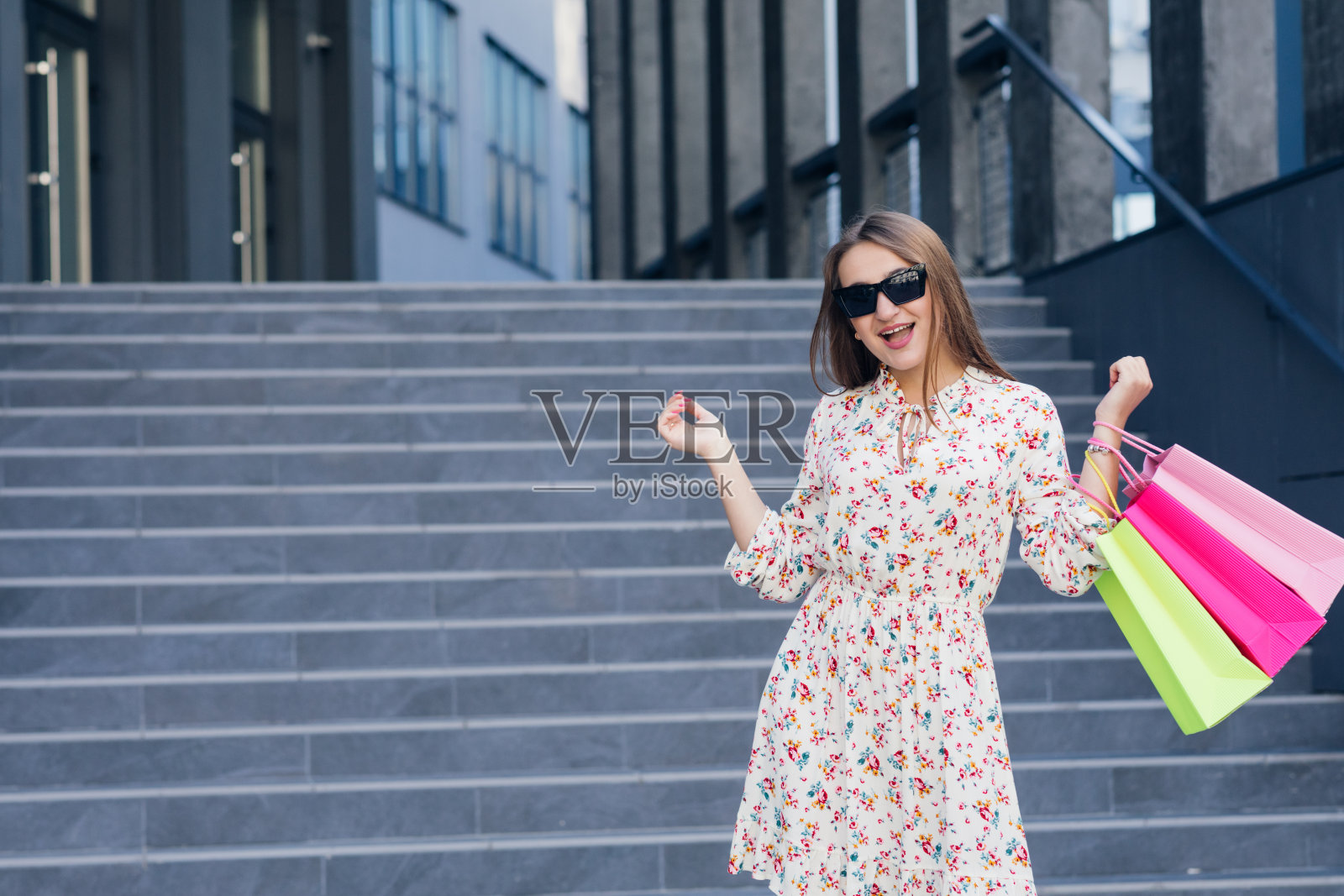 女人在购物。年轻女孩购物后拿着五颜六色的购物袋在城市里散步。消费主义、购物、购物、生活方式的概念照片摄影图片