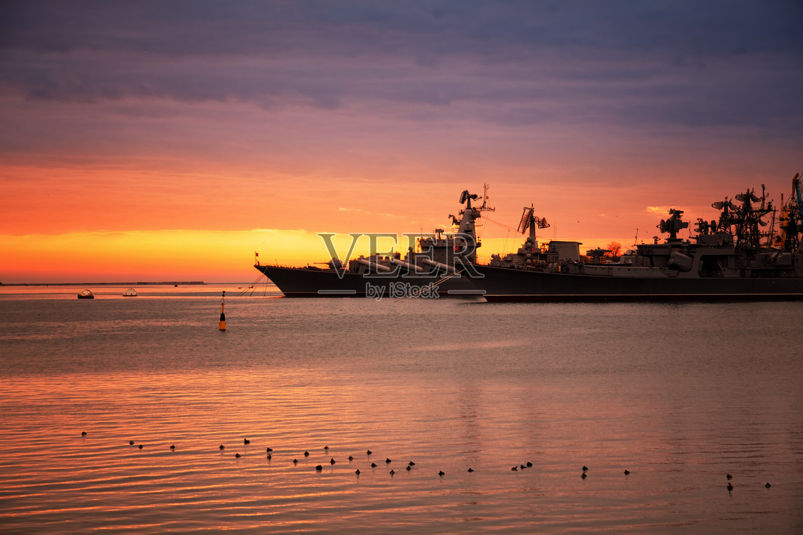 俄罗斯海军在黑海克里米亚。塞瓦斯托波尔湾上的俄罗斯火箭巡洋舰,背景是壮丽的日落照片摄影图片