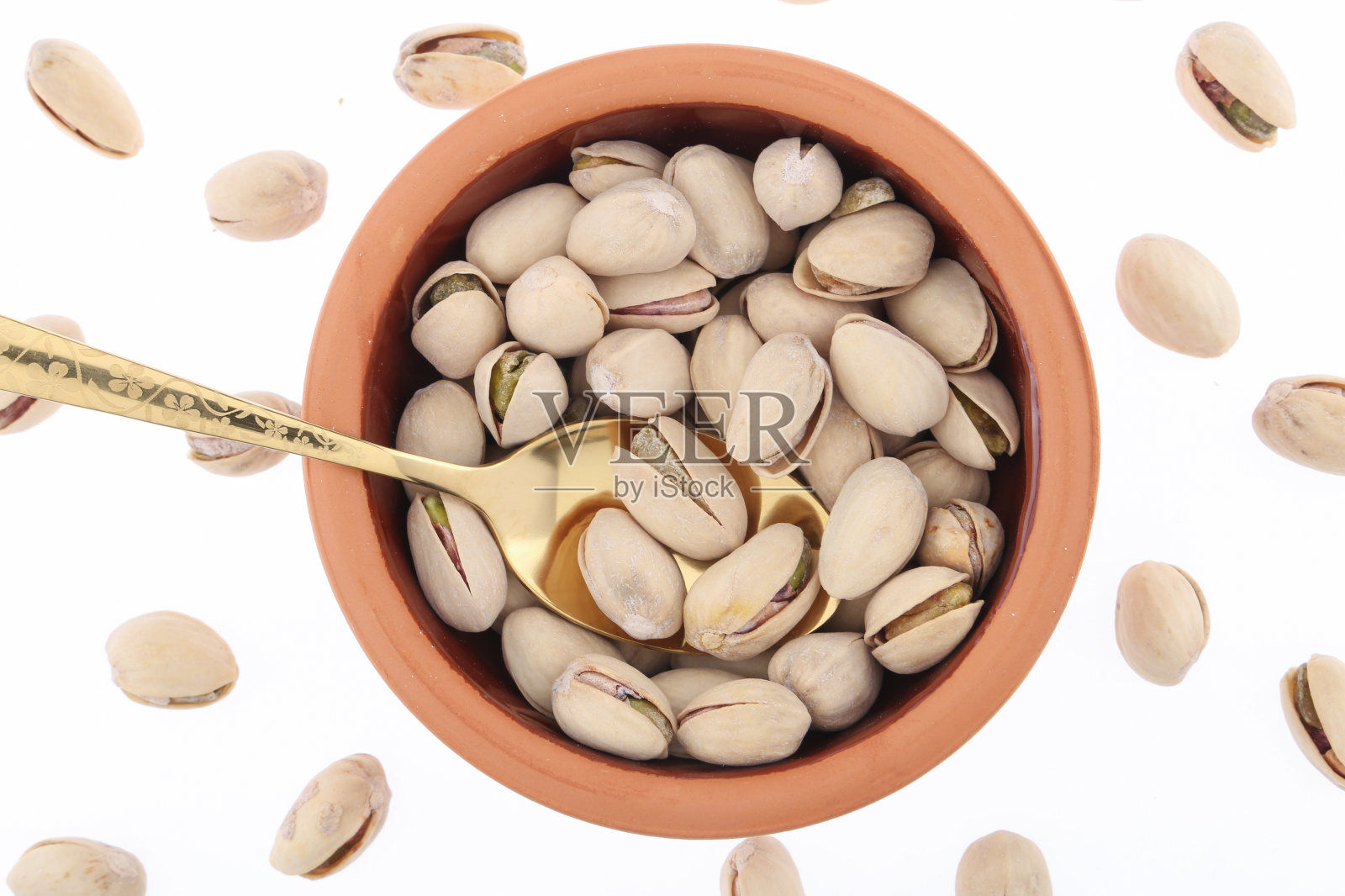 白色瓷碗里的开心果:带壳和去壳的烤开心果种子,绿色干果,完整和切碎的开心果,俯视白色背景的特写食物照片照片摄影图片