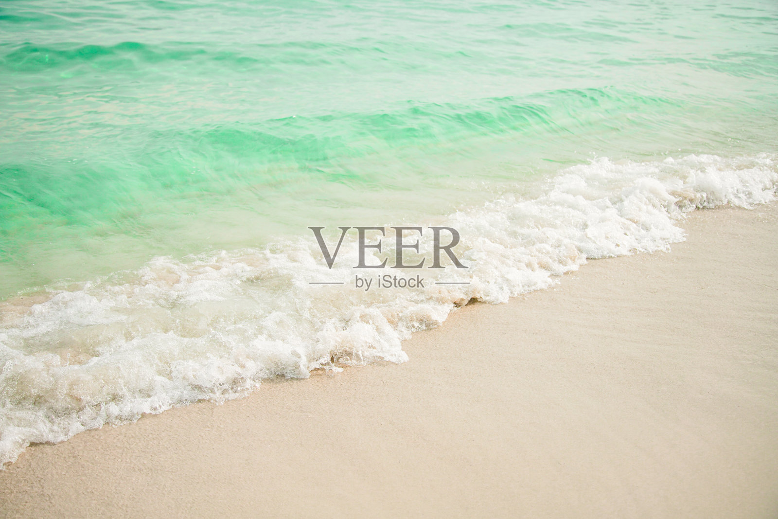 蓝色的海洋,水的阳光反射,和沙子的背景。照片摄影图片