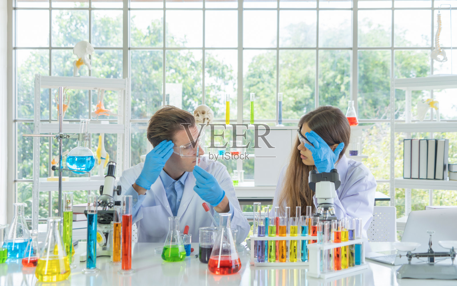 强调了在科技、医学、化学、医疗保健领域的实验室或实验室中,未能通过试管分析和开发covid-19病毒疫苗的西方科学家夫妇。照片摄影图片