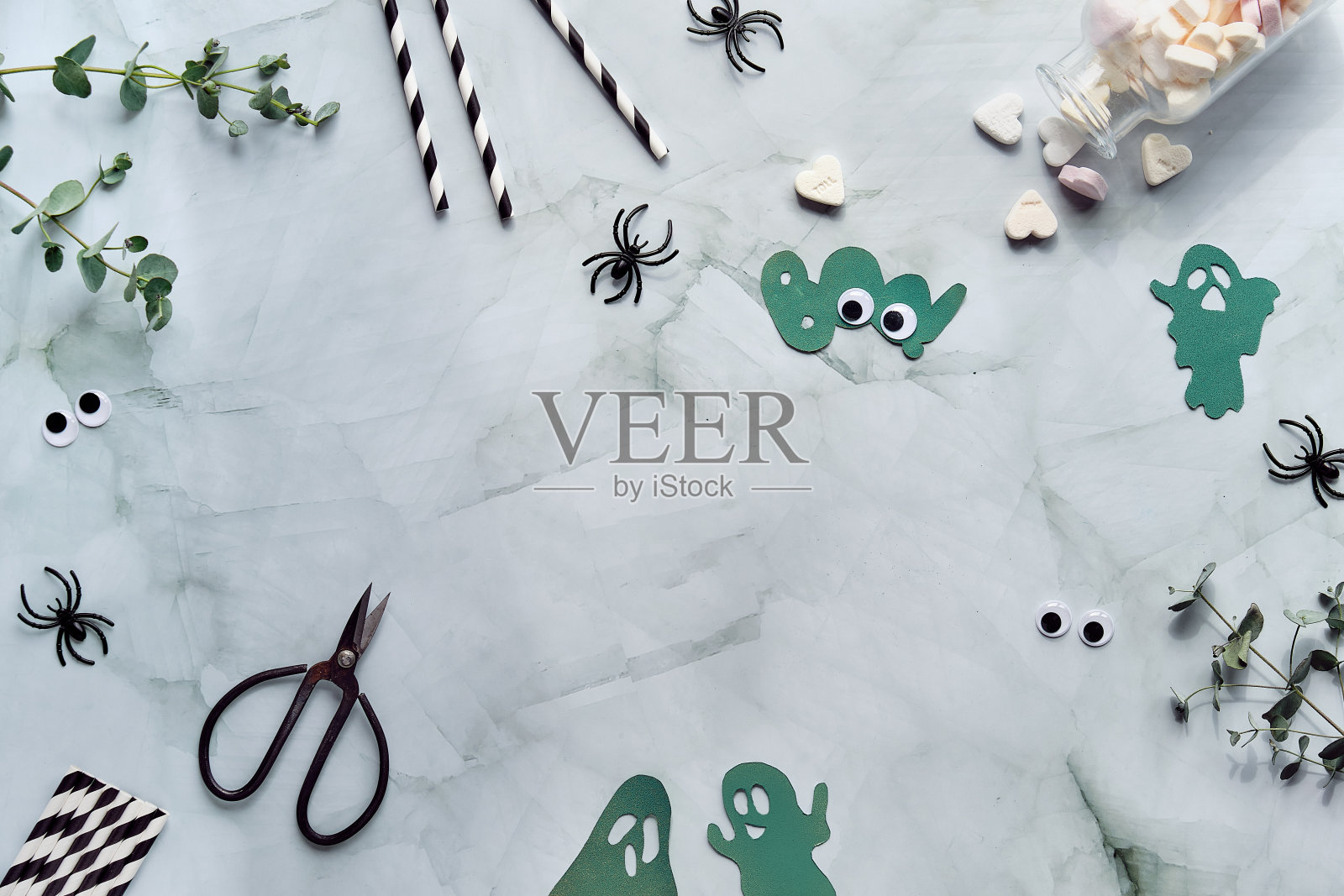 万圣节的夜晚躺着桉树,糖心,黑蜘蛛,剪刀,纸幽灵剪影,单词Boo和复制空间。照片摄影图片