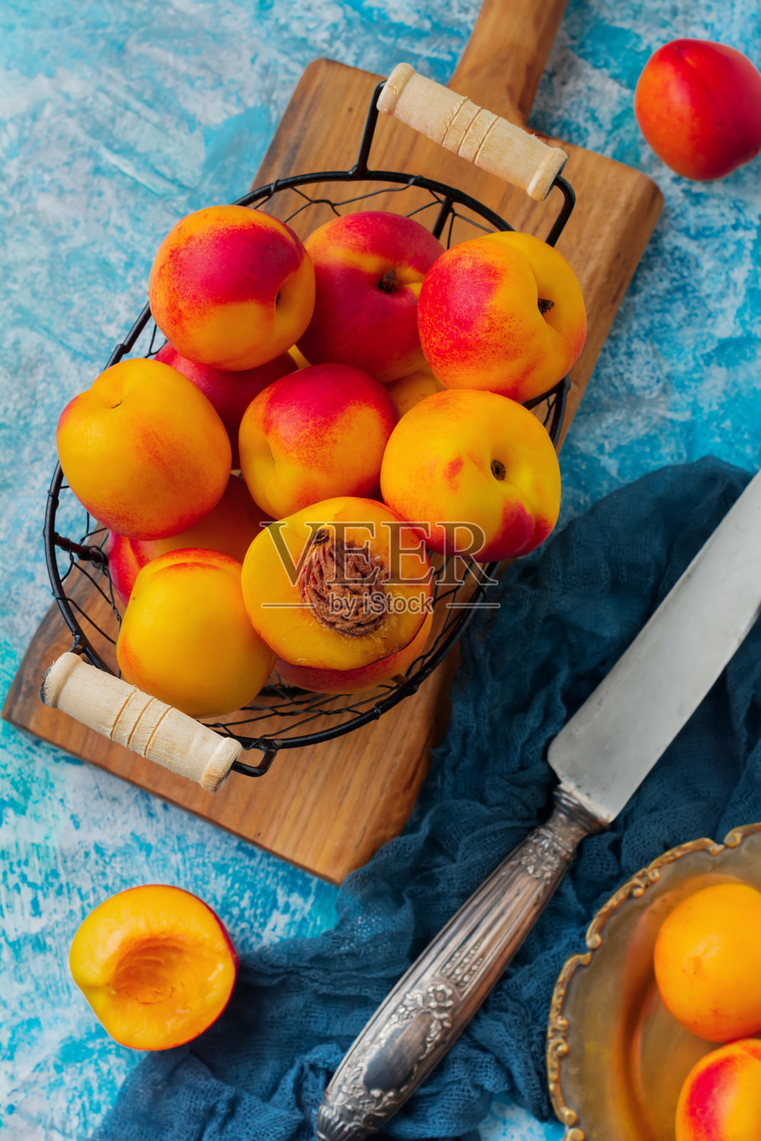新鲜多汁的水果油桃在金属网格上的蓝色混凝土背景。有选择性的重点。前视图。乡村风格。照片摄影图片