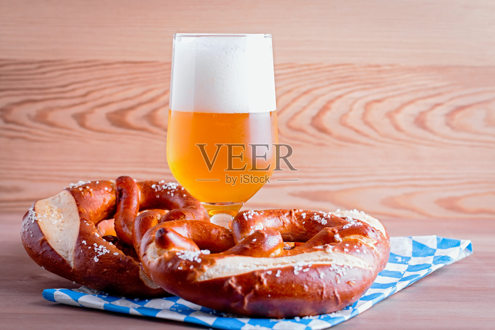 啤酒节的背景与啤酒和椒盐卷饼和传统巴伐利亚装饰的木制桌面特写照片摄影图片