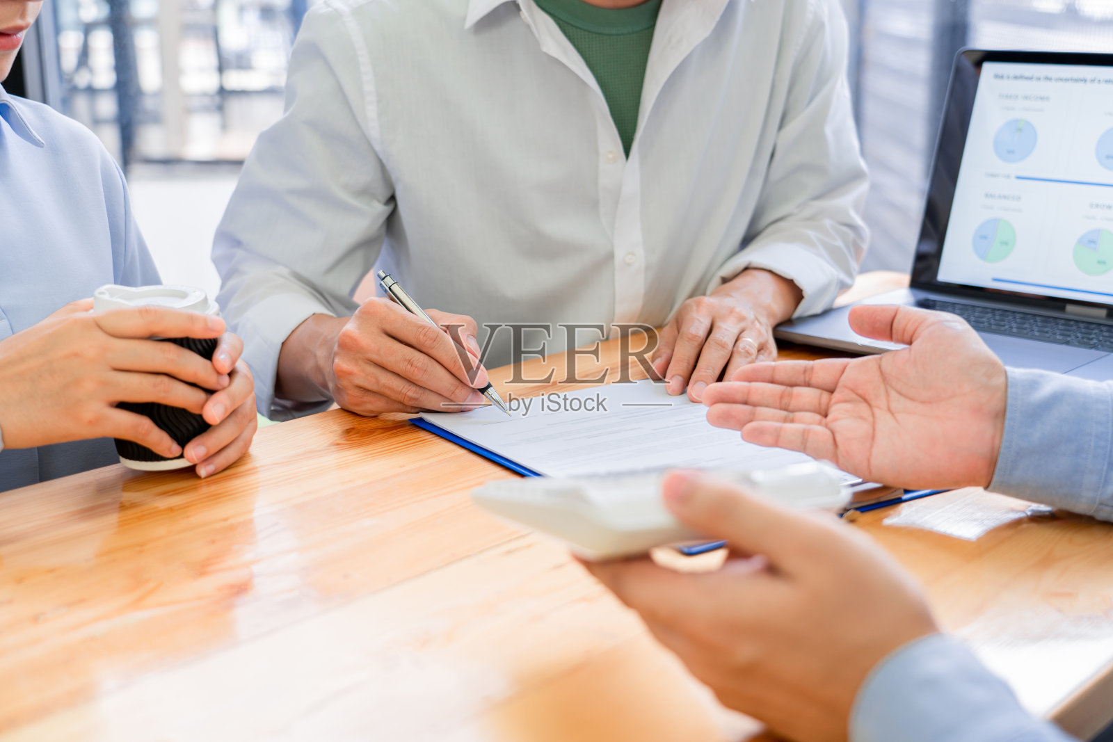 年轻的亚洲夫妇在家中接受理财顾问的指导,讨论投资理财计划后,心情愉快。照片摄影图片