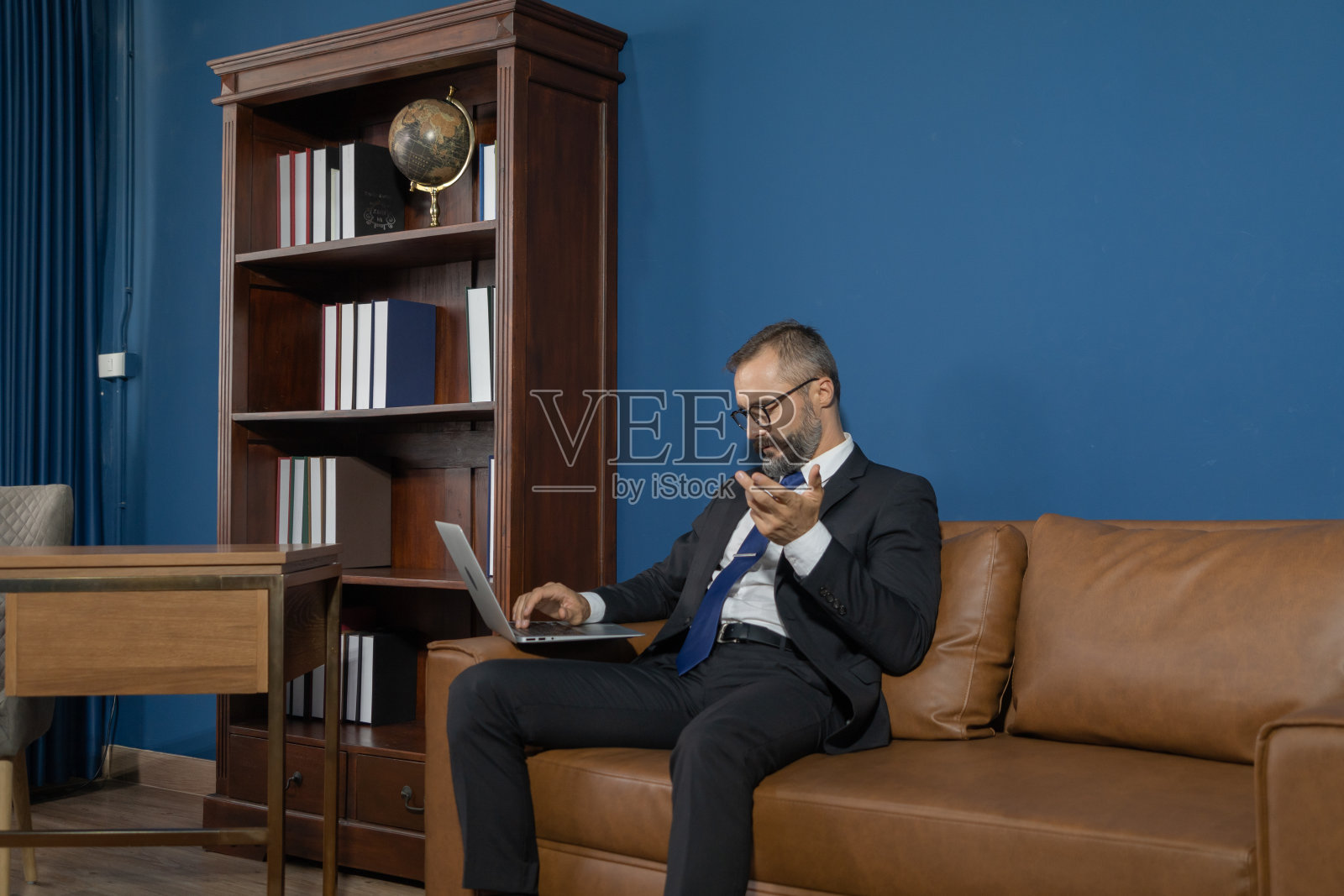 微笑的商业复古,白人绅士,白种人的工作,从家里的桌子上的电脑笔记本电脑上的摄像头视频电话会议在检疫在复古时尚设计。照片摄影图片