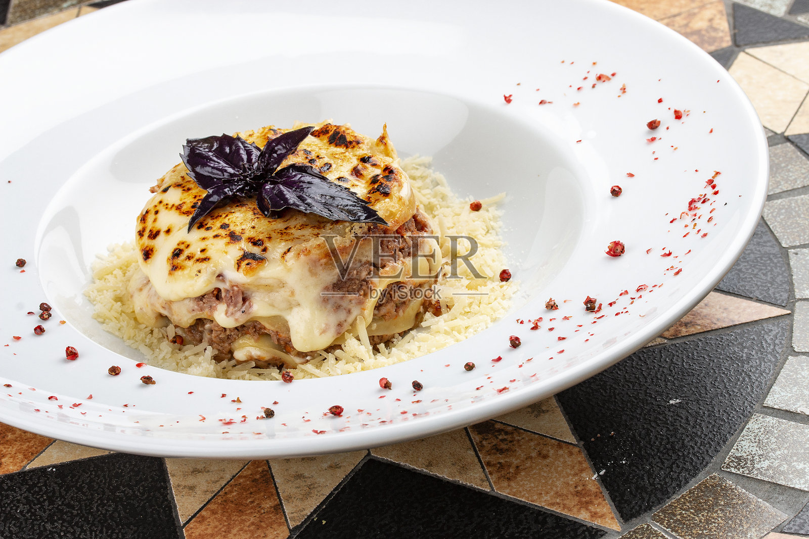 传统的意大利千层面是用肉酱末配上香菜叶,盛在白色的盘子里照片摄影图片