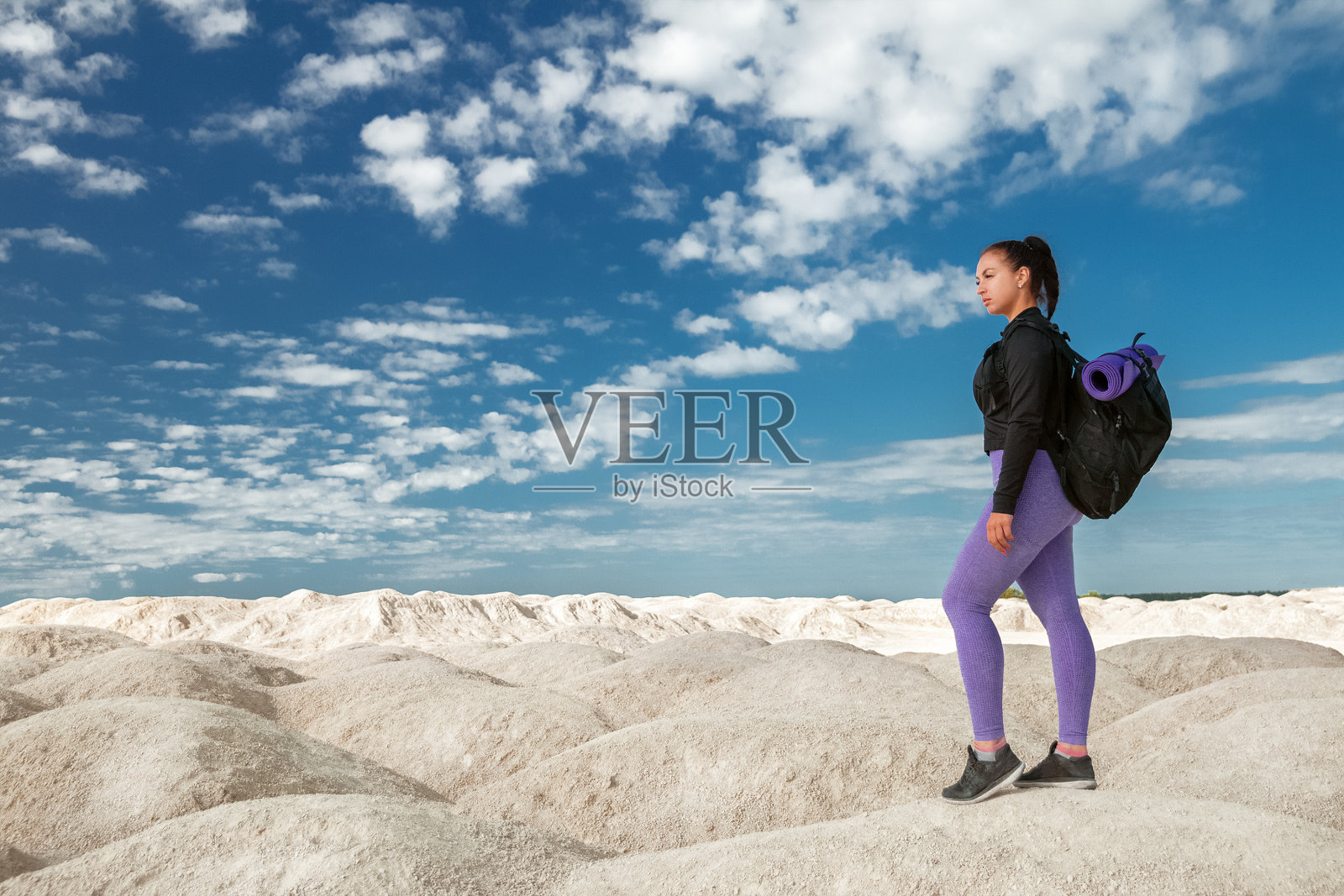 年轻女子在山上的一个游客在阳光明媚的日子里,在运动服装和背包望向远方,独自旅游的概念,目标,愿望,克服照片摄影图片