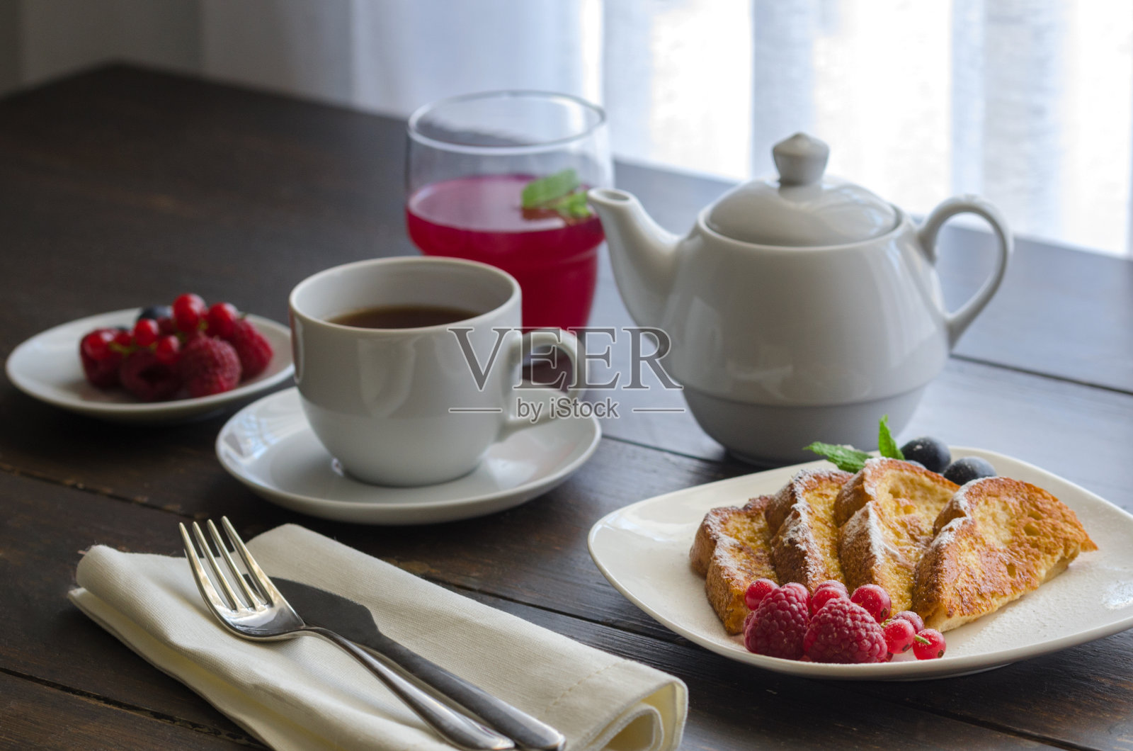酒店餐厅的早餐是西班牙烤面包或法国烤面包加浆果和糖霜。照片摄影图片