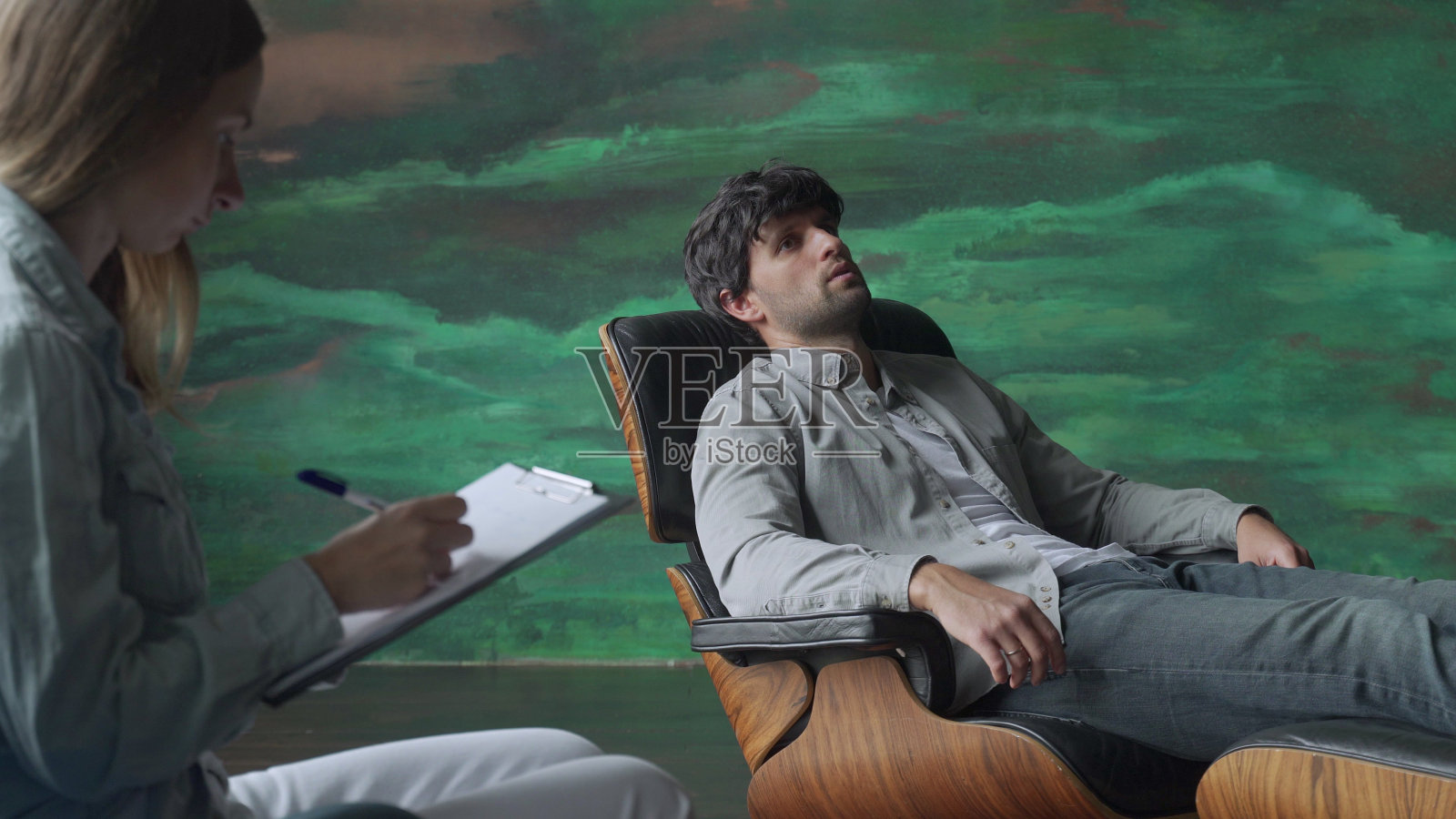 当病人躺在沙发上谈论问题时,心理健康专家会记录下来照片摄影图片