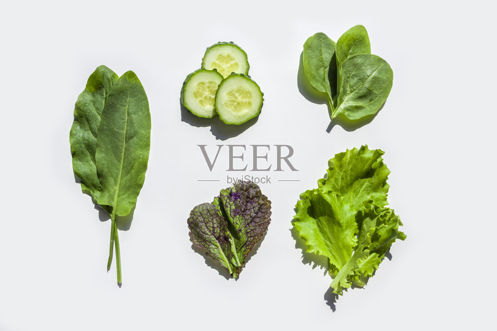 白色背景上的新鲜绿色沙拉配料图案。平铺生菜、菠菜、芥菜、酸模、黄瓜的叶子。健康饮食。有机及素食照片摄影图片