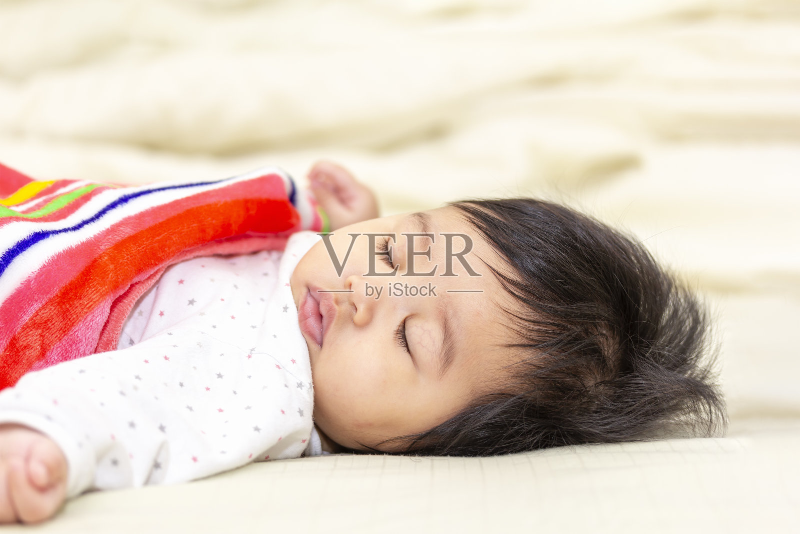 肖像亚洲可爱的婴儿在一个毯子睡在床上的房间照片摄影图片