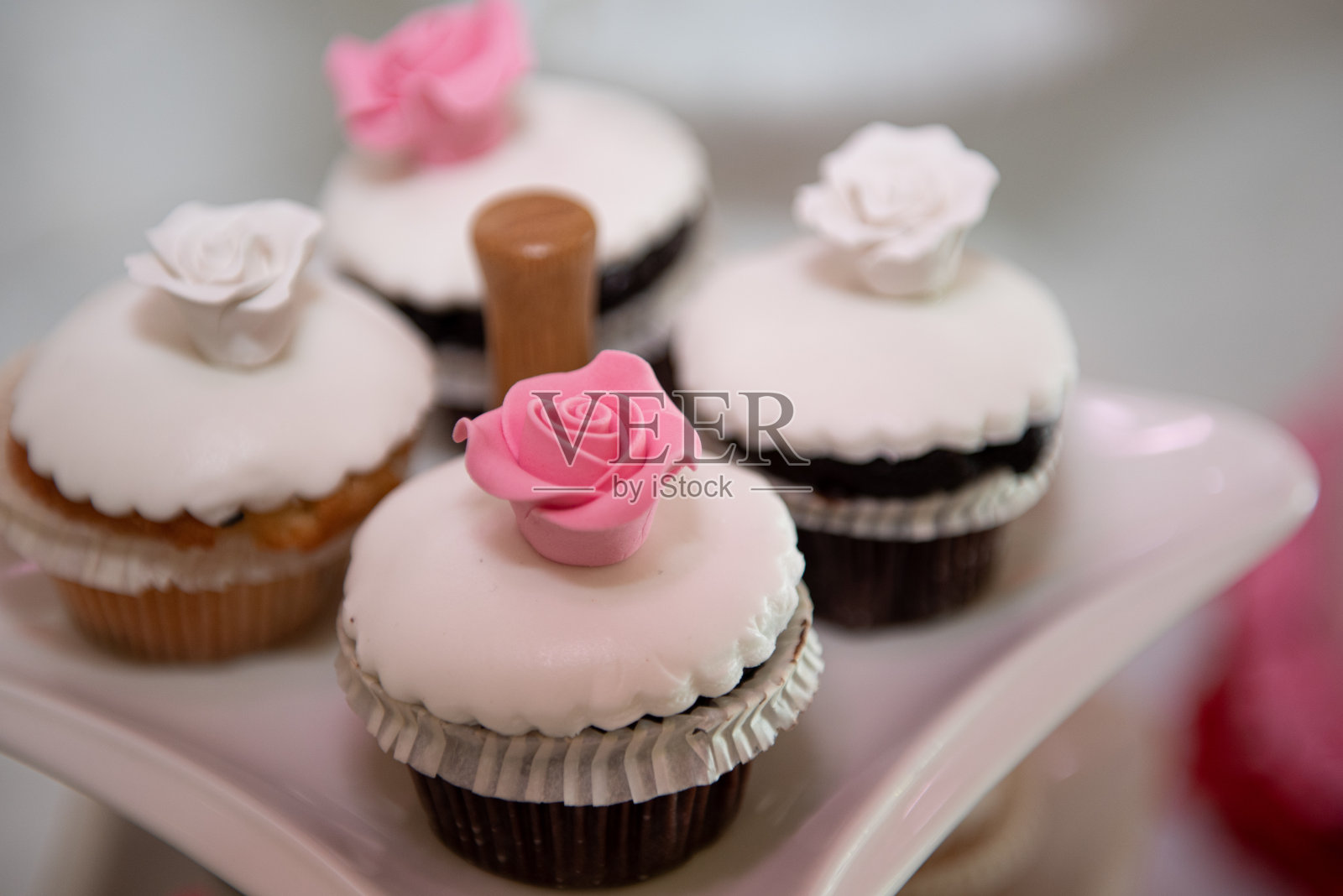 新鲜美味的纸杯蛋糕,上面点缀着白糖和粉红色的花朵照片摄影图片