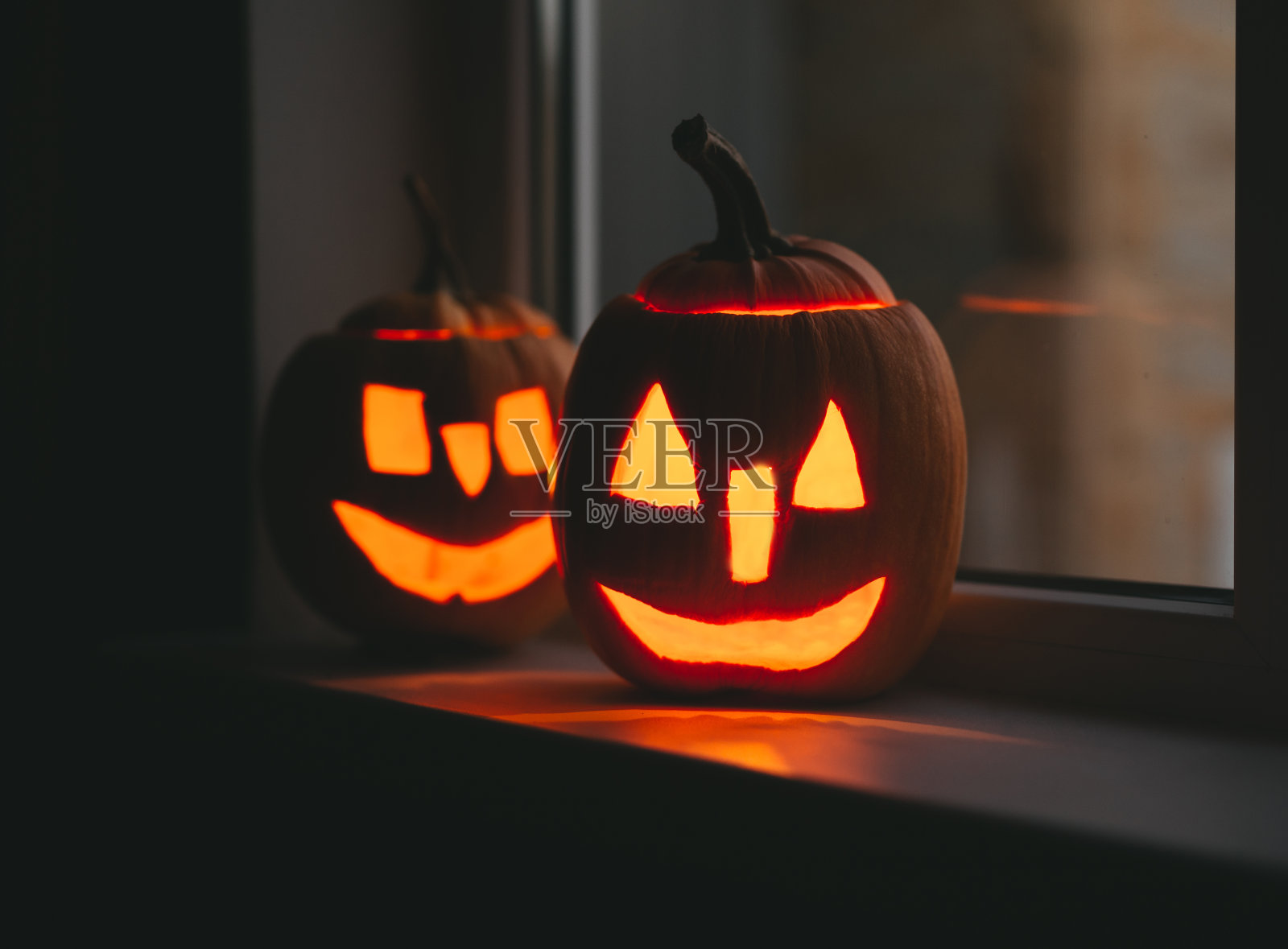 万圣节的南瓜在窗户上与散焦。万圣节快乐一天照片摄影图片