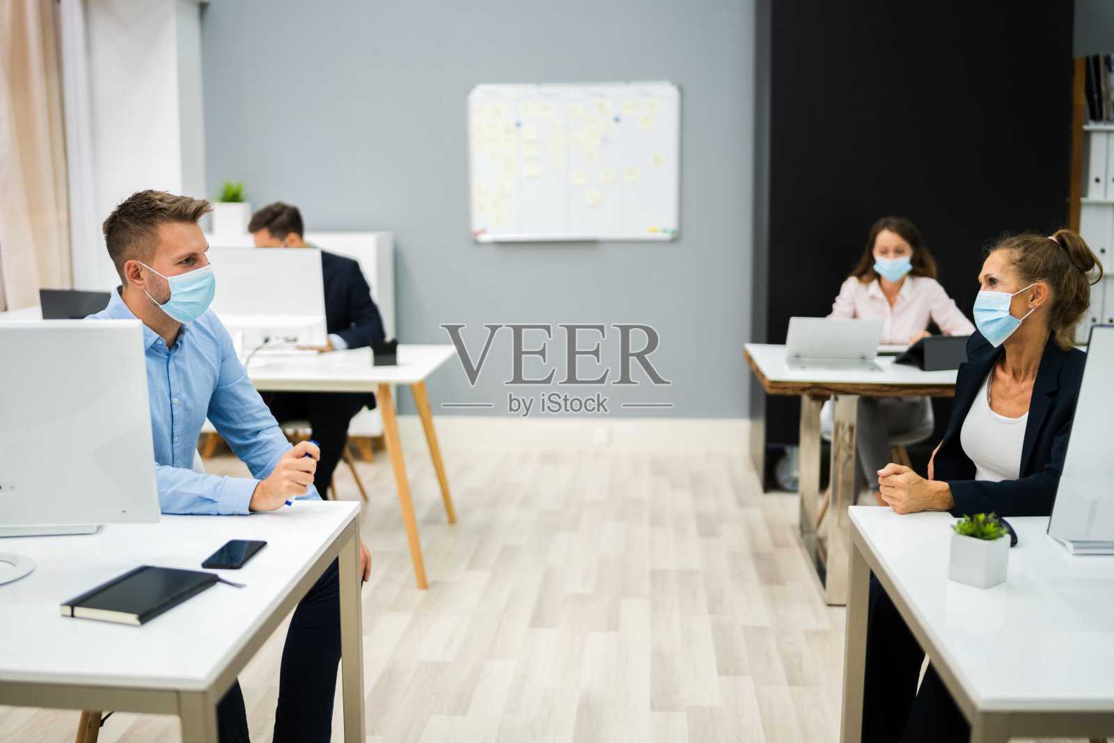 商务人士使用社交距离交谈照片摄影图片