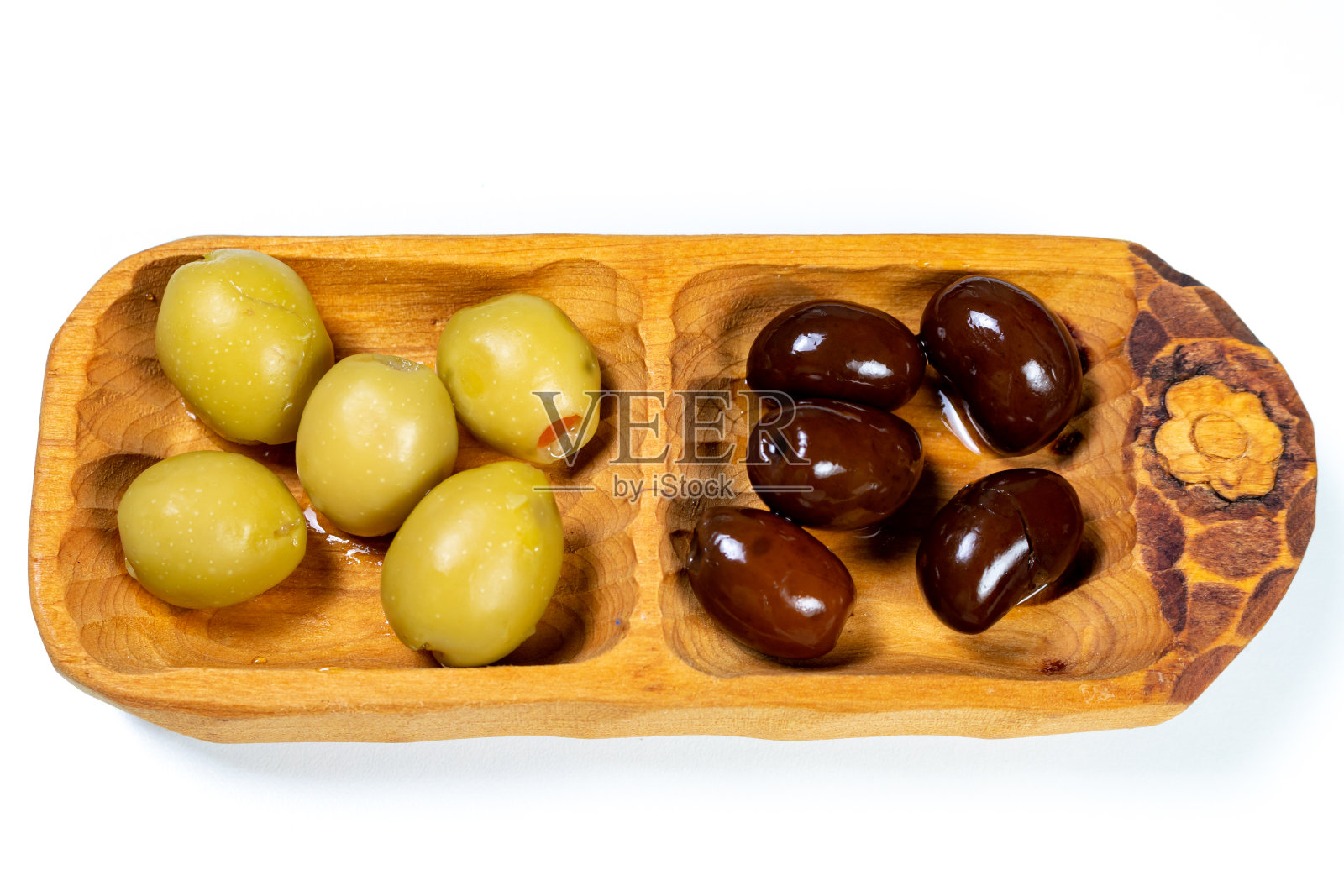 黑色和绿色的橄榄在一个小木碗在白色的表面背景照片摄影图片