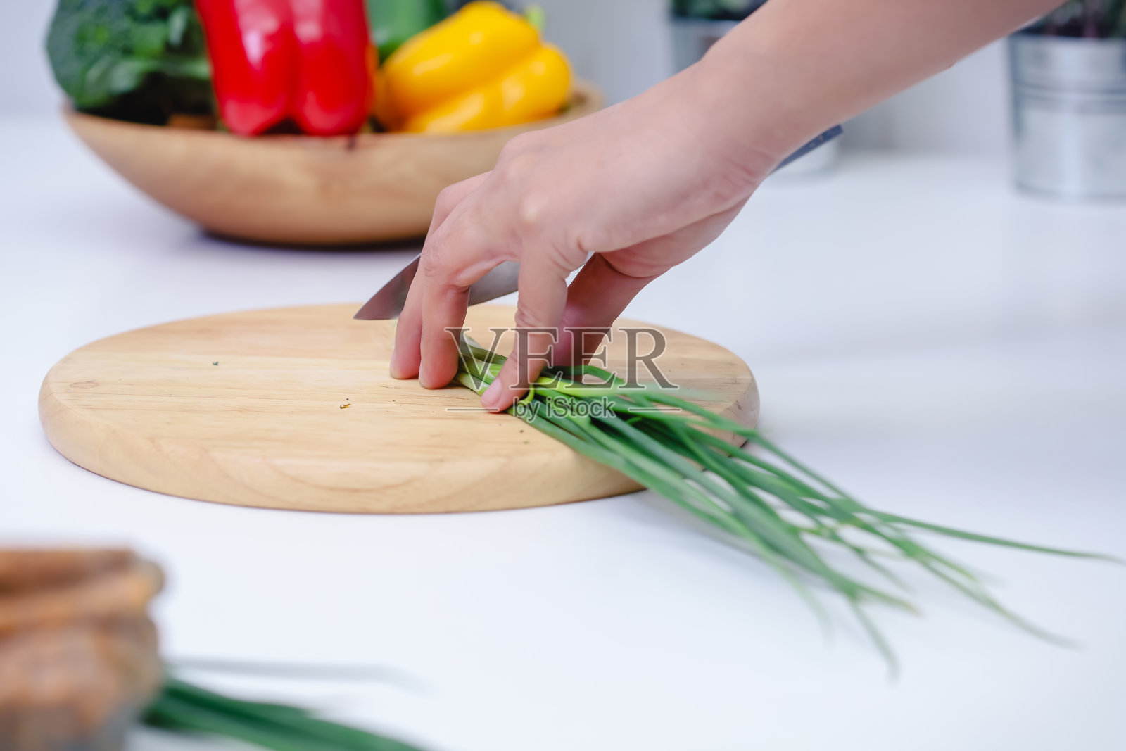女人在厨房里用手切葱。厨师烹饪素食。照片摄影图片
