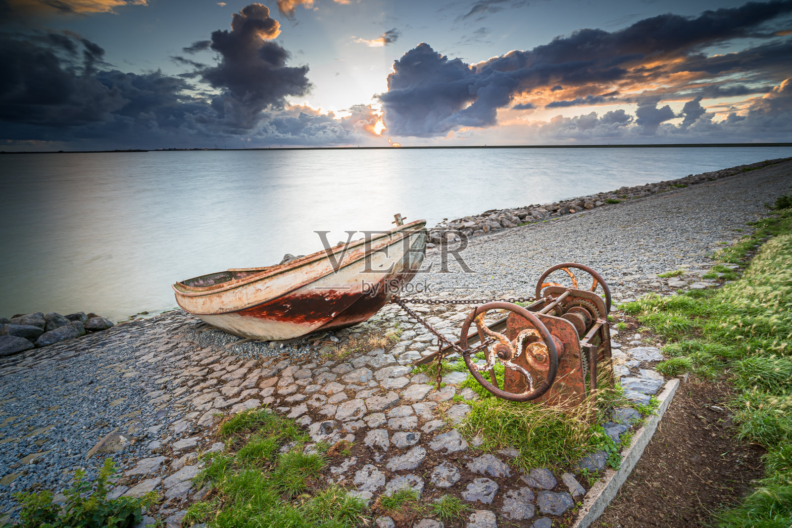 一艘生锈的老渔船停在湖边的斜坡上照片摄影图片