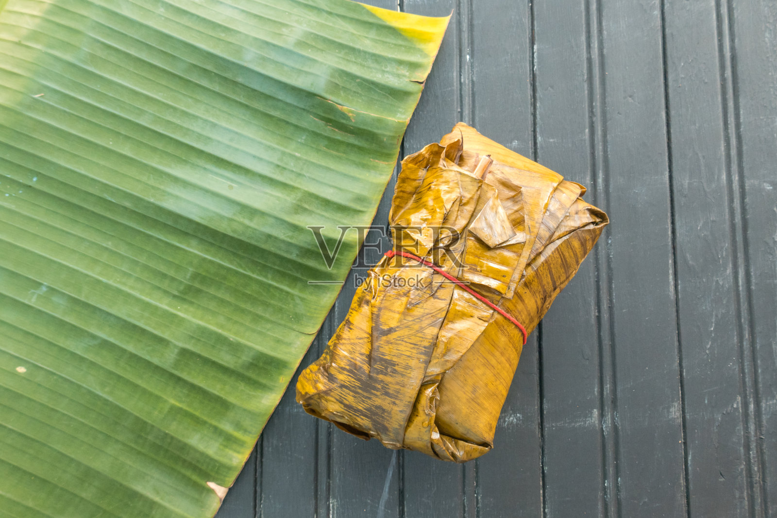 哥伦比亚玉米粉蒸肉裹在香蕉和棕榈树的叶子里照片摄影图片