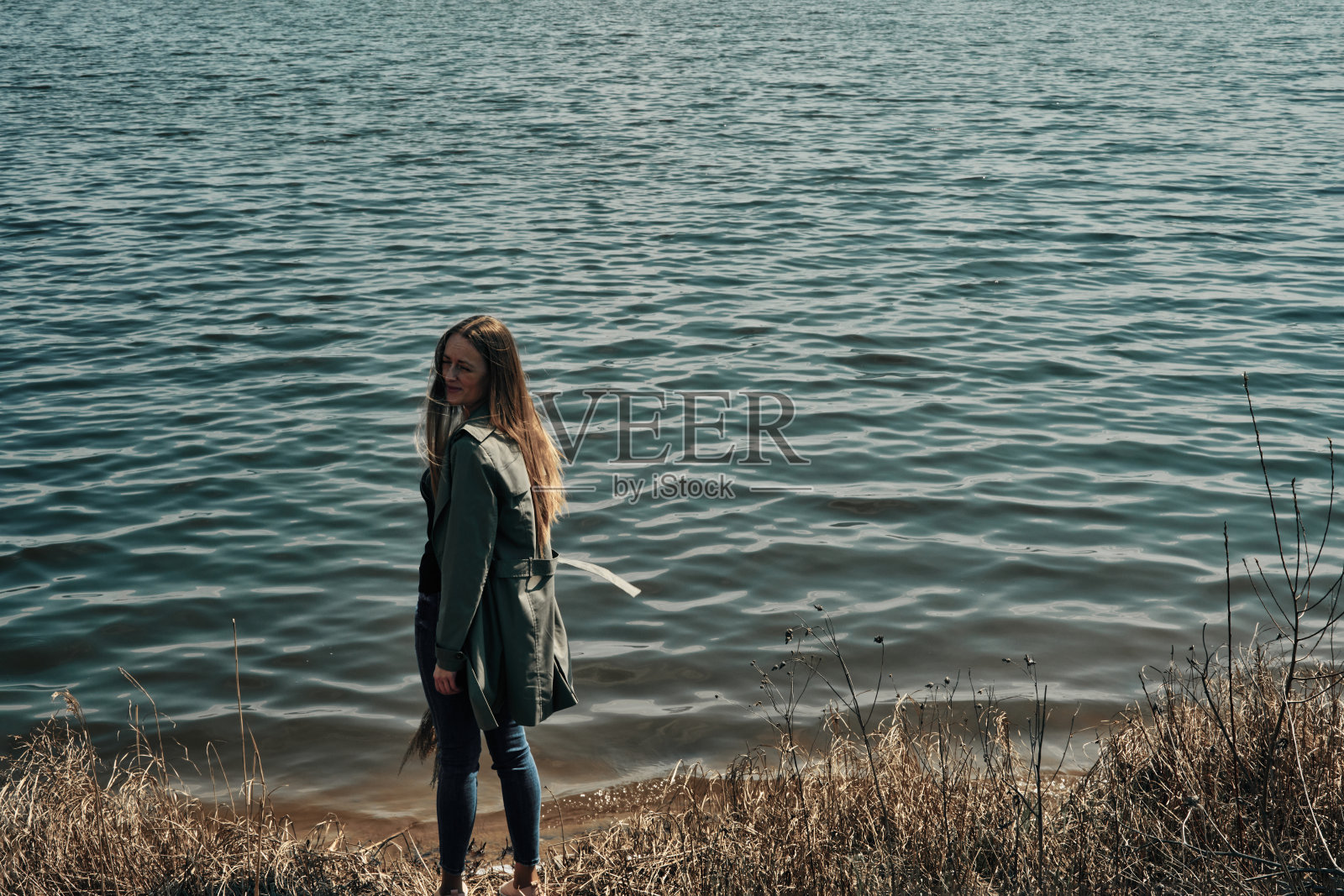 那女孩沿着湖岸散步。下降。露营。极简主义。照片摄影图片