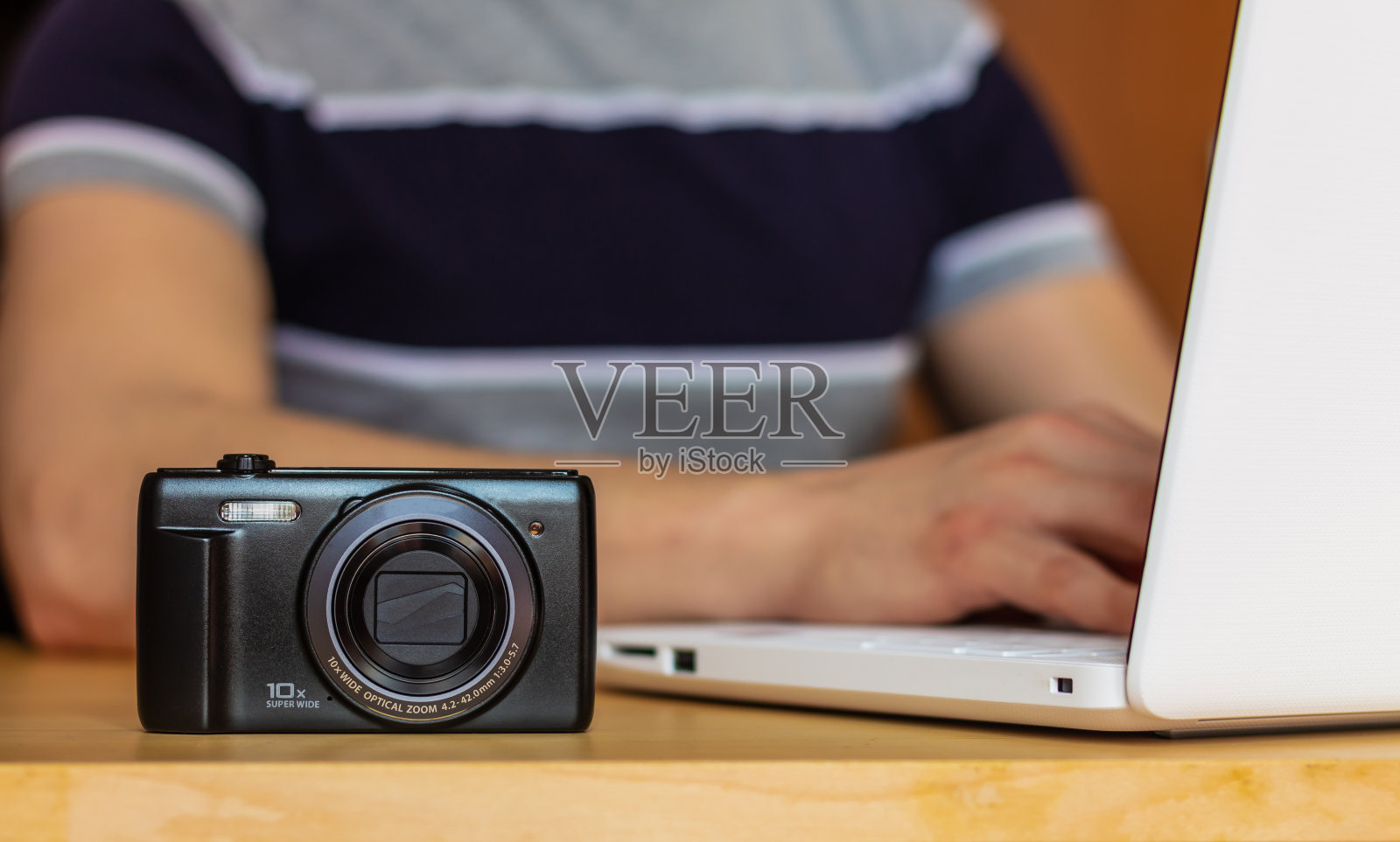 一个照片的特写在桌子上,一个穿着现代的男人在家里或办公室工作。照片摄影图片