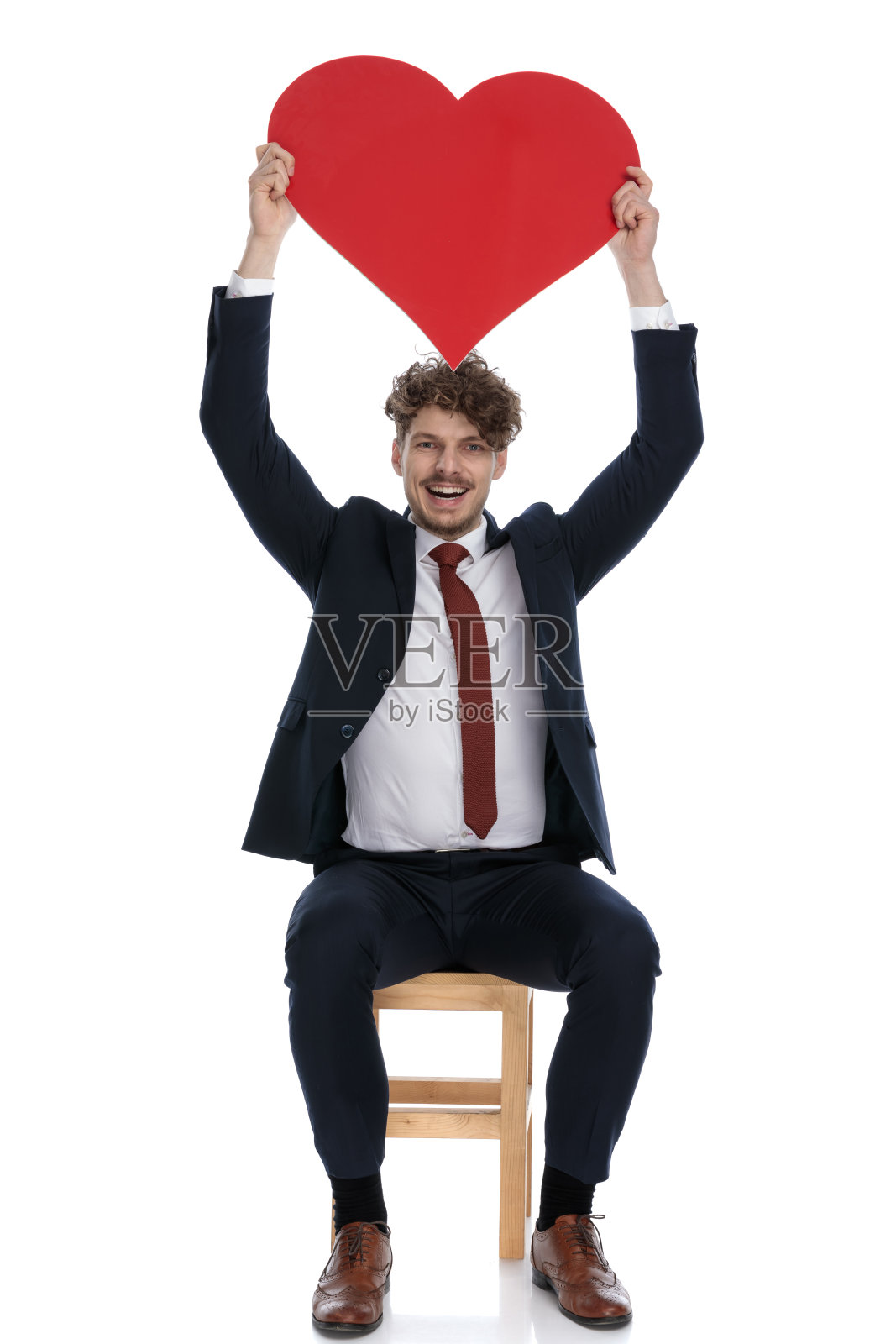 兴奋的商人举着一颗巨大的红心照片摄影图片