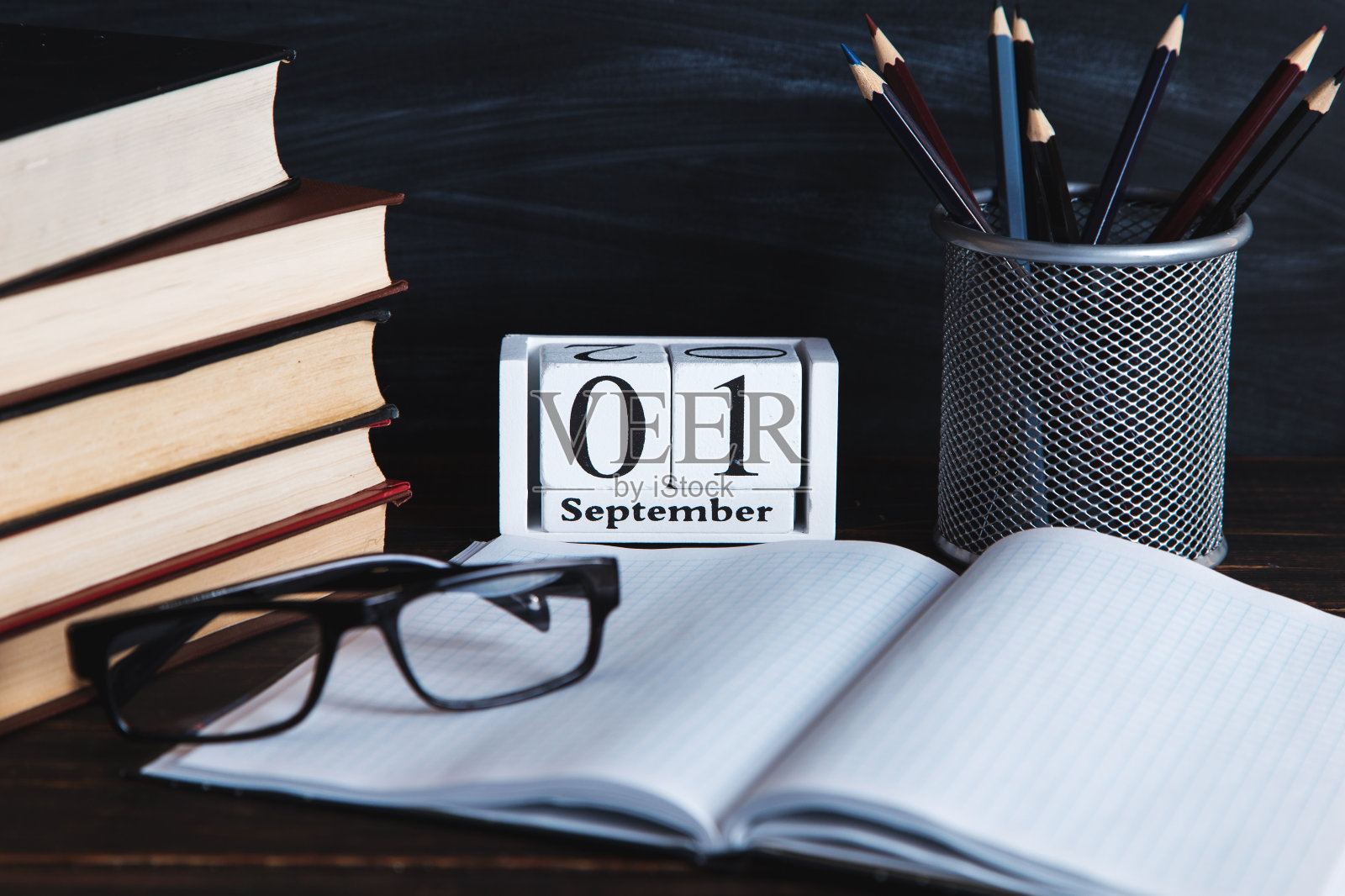 书、日历、笔记本、铅笔、玻璃杯和一杯咖啡,背景是黑板。概念知识日。副本的空间。照片摄影图片