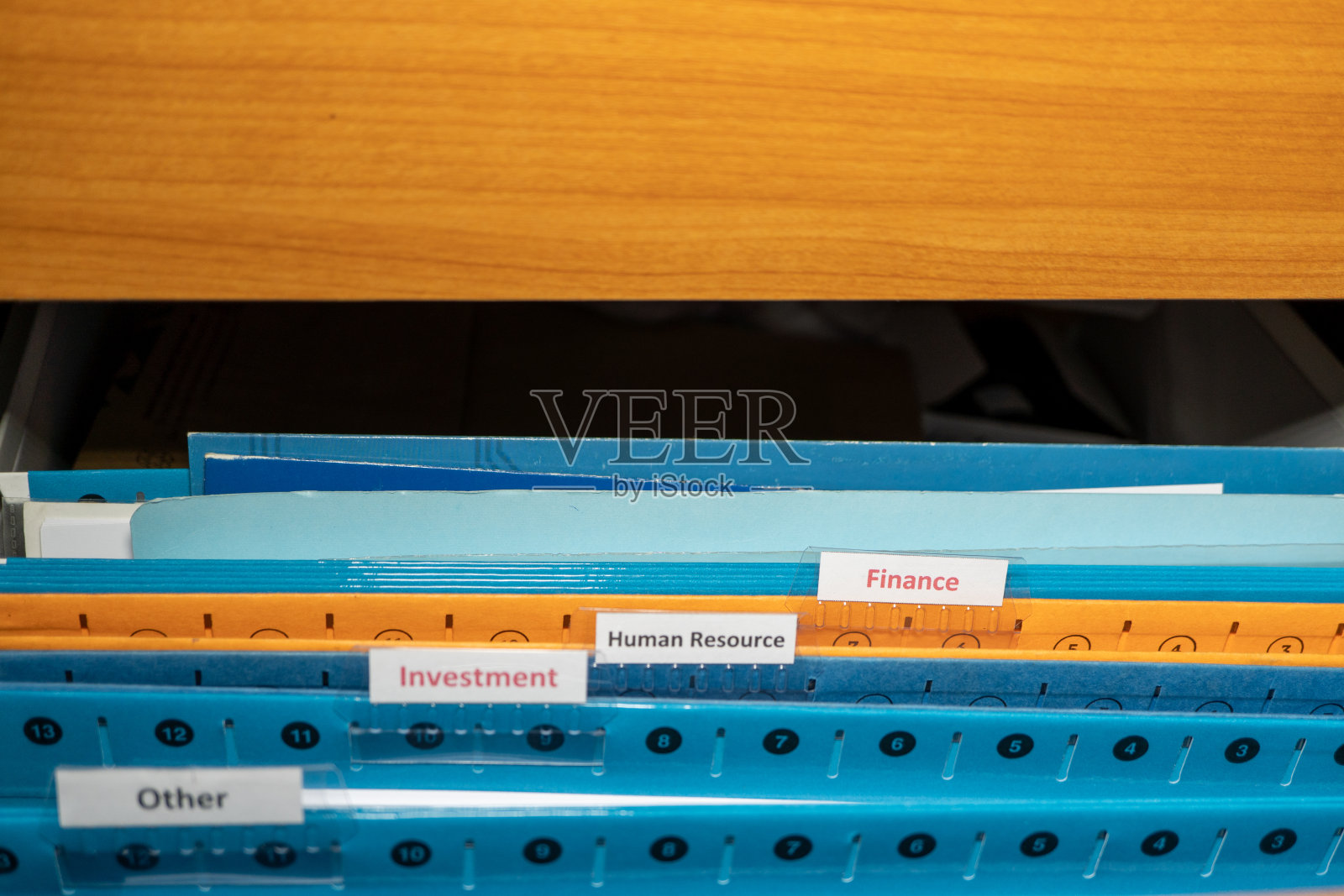 财务文件,红色字体的文件夹在木文件柜。有选择性的重点。照片摄影图片