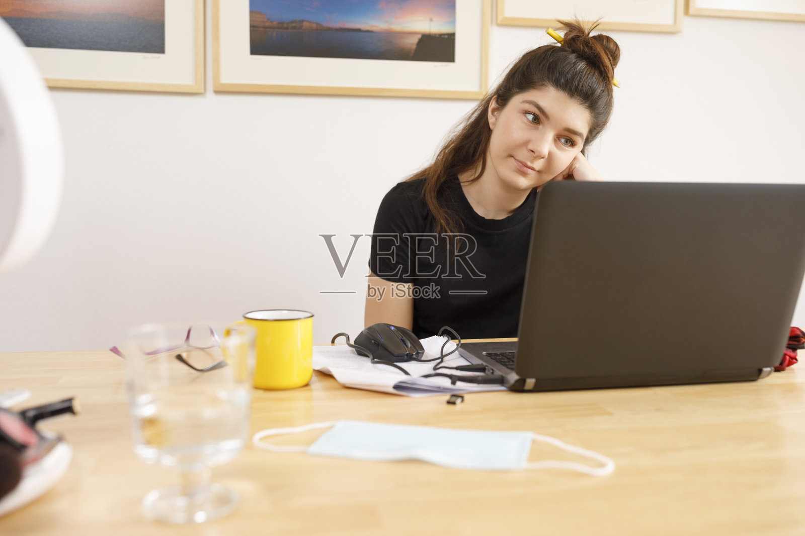 女学生在家办公,用笔记本电脑记笔记和进行电子学习照片摄影图片