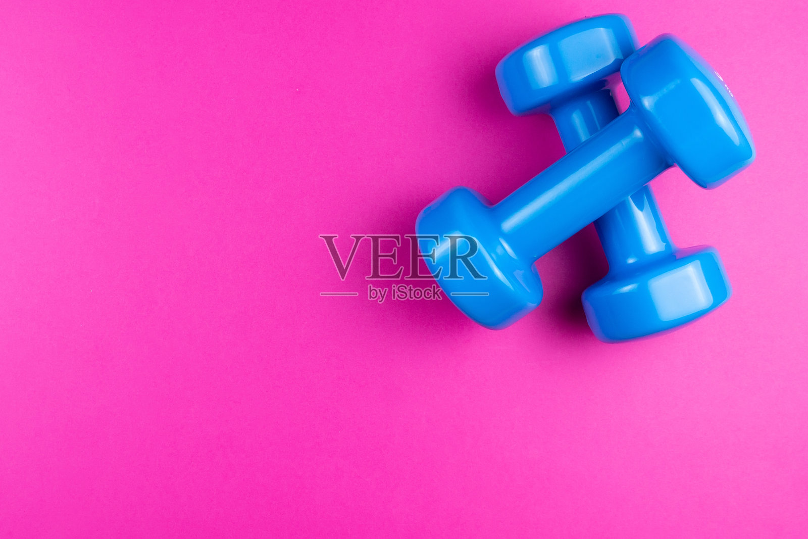 粉色背景上的哑铃照片摄影图片