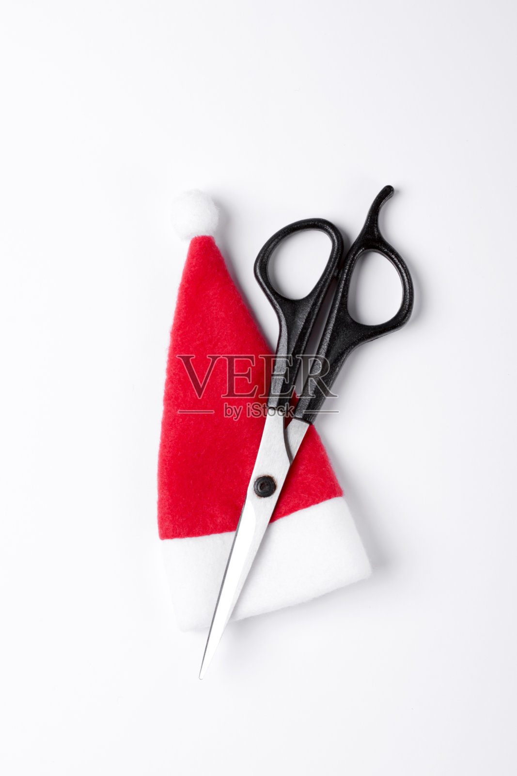 剪子和圣诞老人帽映衬着白色的背景照片摄影图片