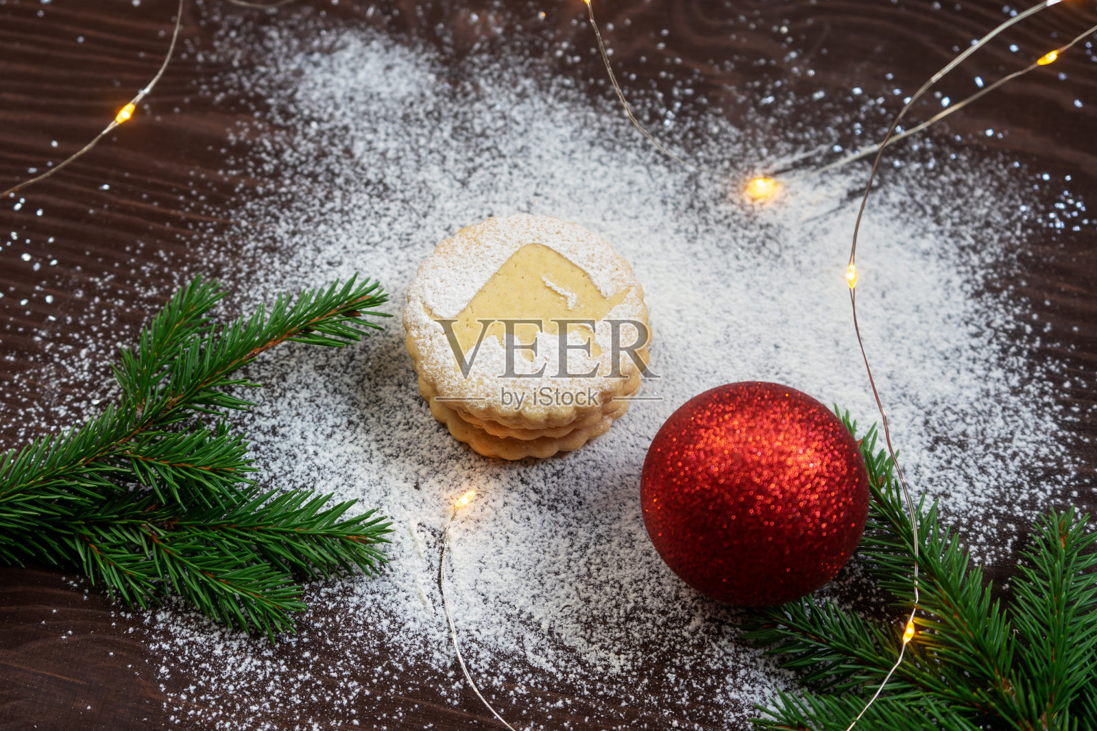 用饼干、云杉树枝和装饰品装饰的圣诞节日布局。脆饼与公牛的剪影特写。照片摄影图片