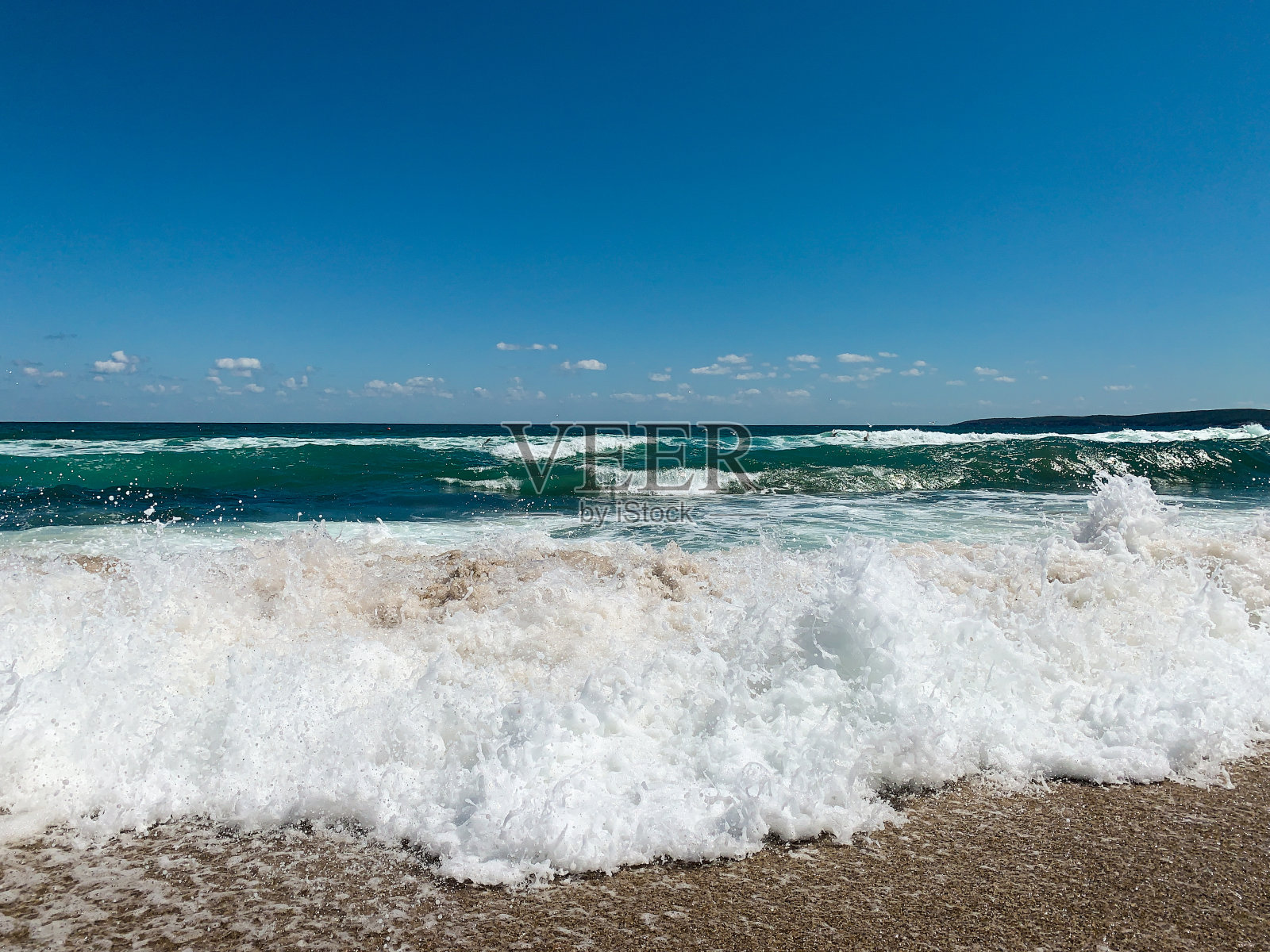 碧绿的海水,白色的浪花拍打着海岸照片摄影图片