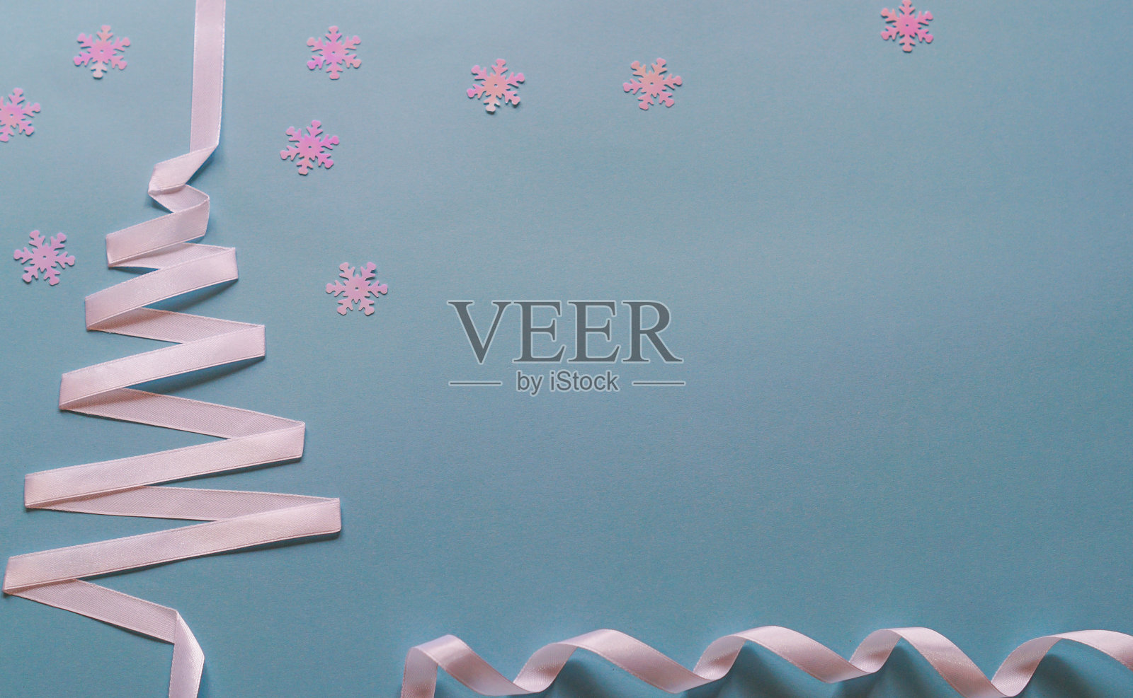 节日,冬季和庆祝概念-圣诞和新年树由白色缎带和雪花在蓝色背景自由空间文本。照片摄影图片