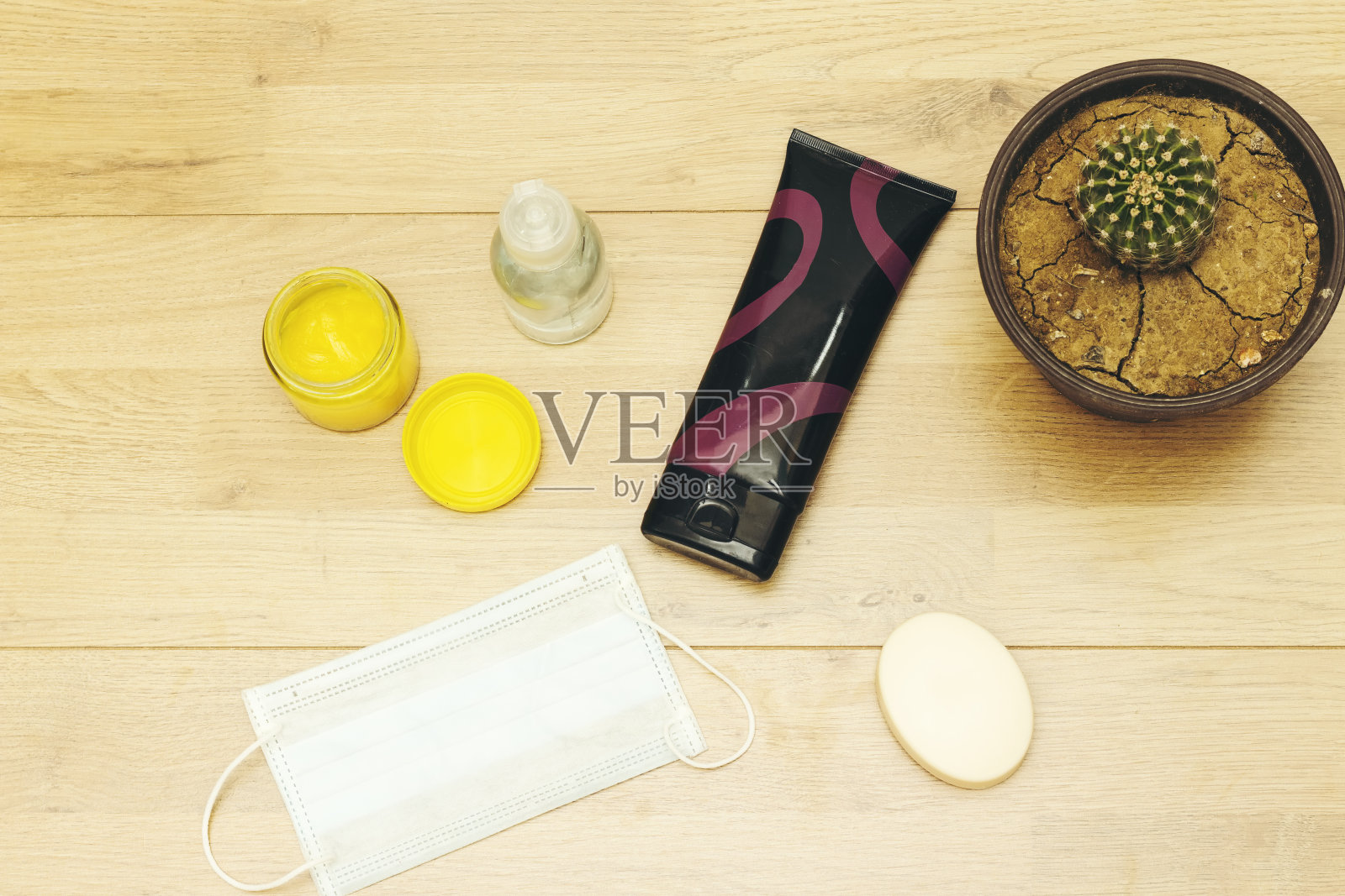 木桌上放肥皂泡沫条、奶油管和医用口罩照片摄影图片
