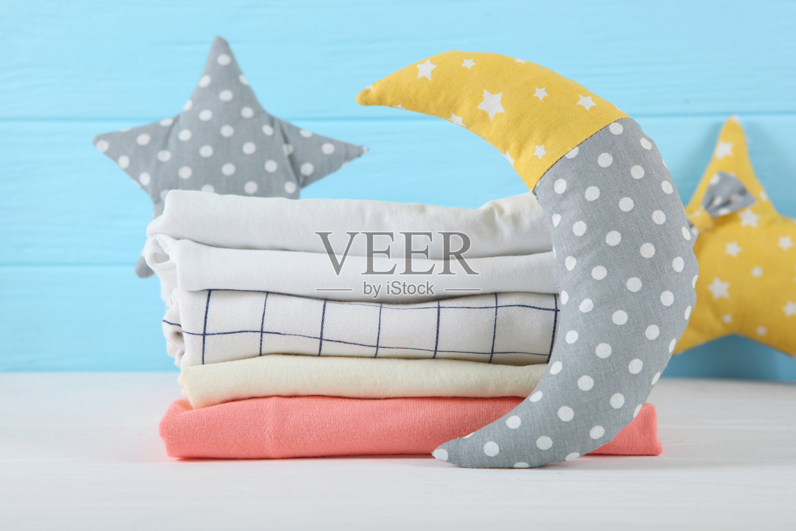 浅色背景上的一堆婴儿衣服。照片摄影图片