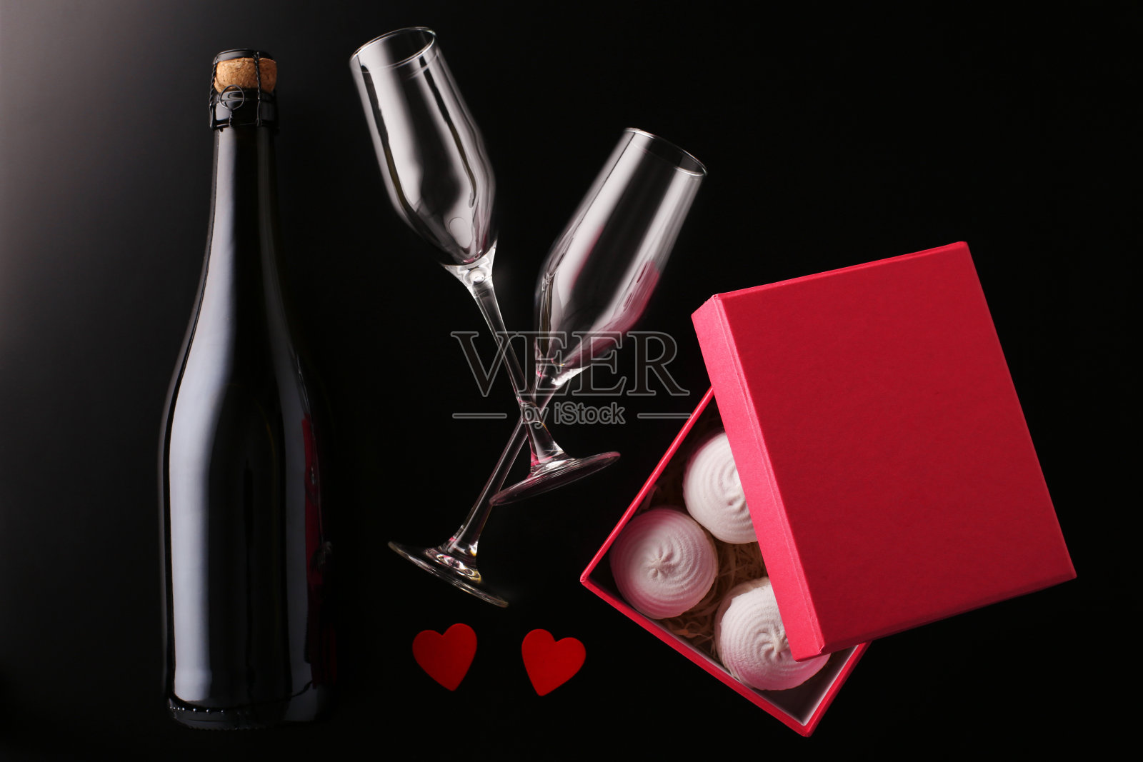 情人节贺卡。酒瓶起泡酒与玻璃和礼盒在黑色背景照片摄影图片
