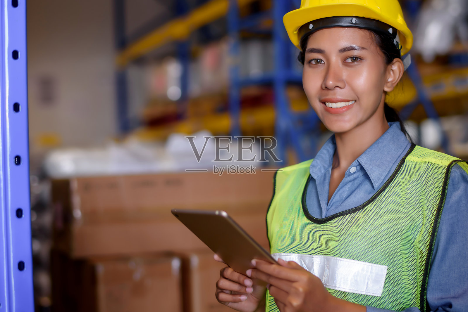 工程师仓库女工戴安全帽站在货物仓库,检查货物从货轮进口和出口的控制装载通过平板报告。团队合作理念照片摄影图片