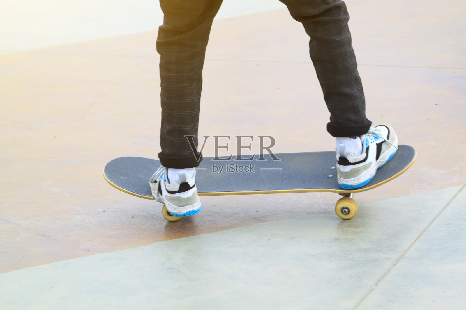 滑板和人的腿骑在它在户外滑板公园近距离照片摄影图片